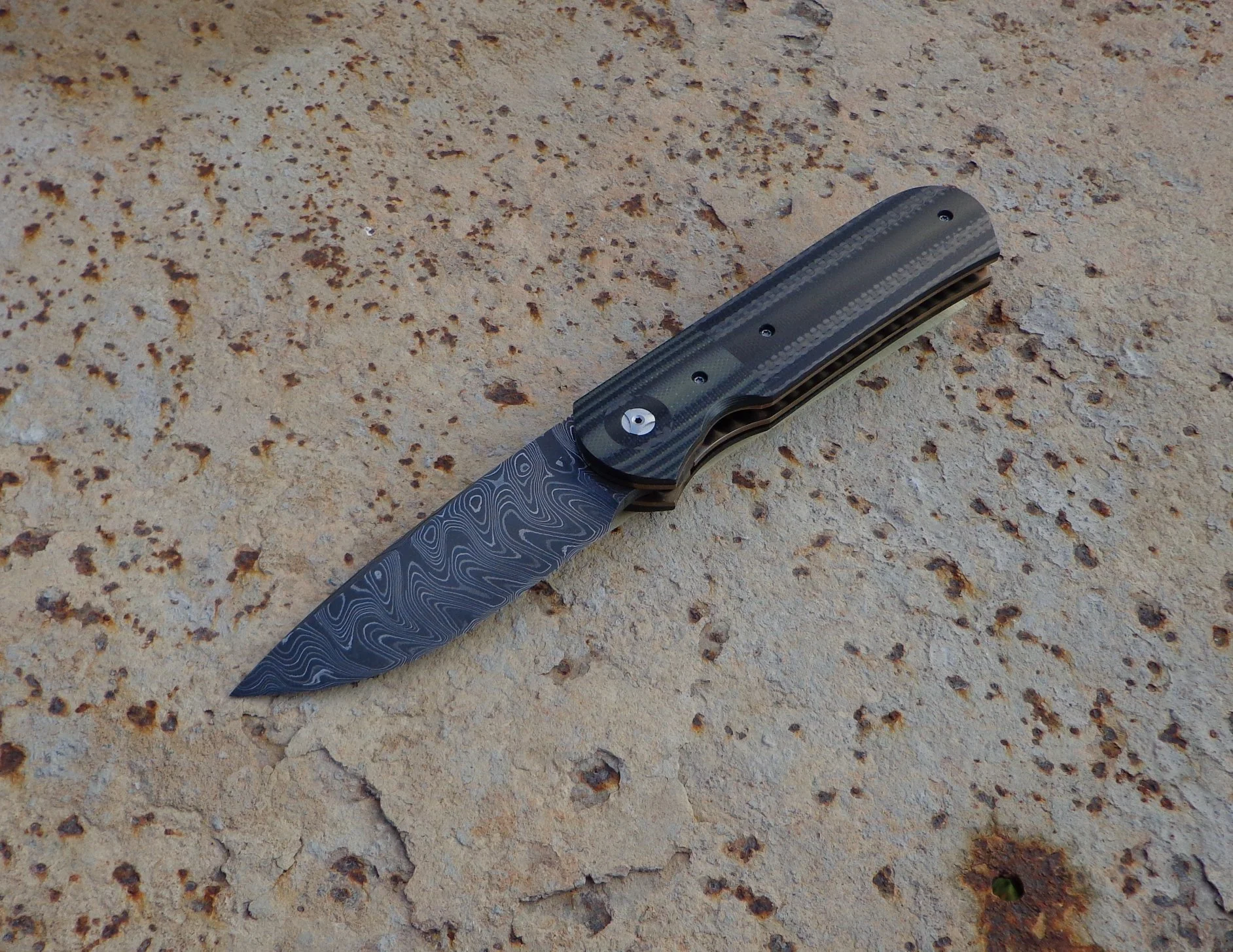 Knife: Samson Liner Lock. Alabama Damascus Steel Blade. Titanium liners. Carbon Fiber and G10 handle. Alabama Damascus Steel belt clip.
