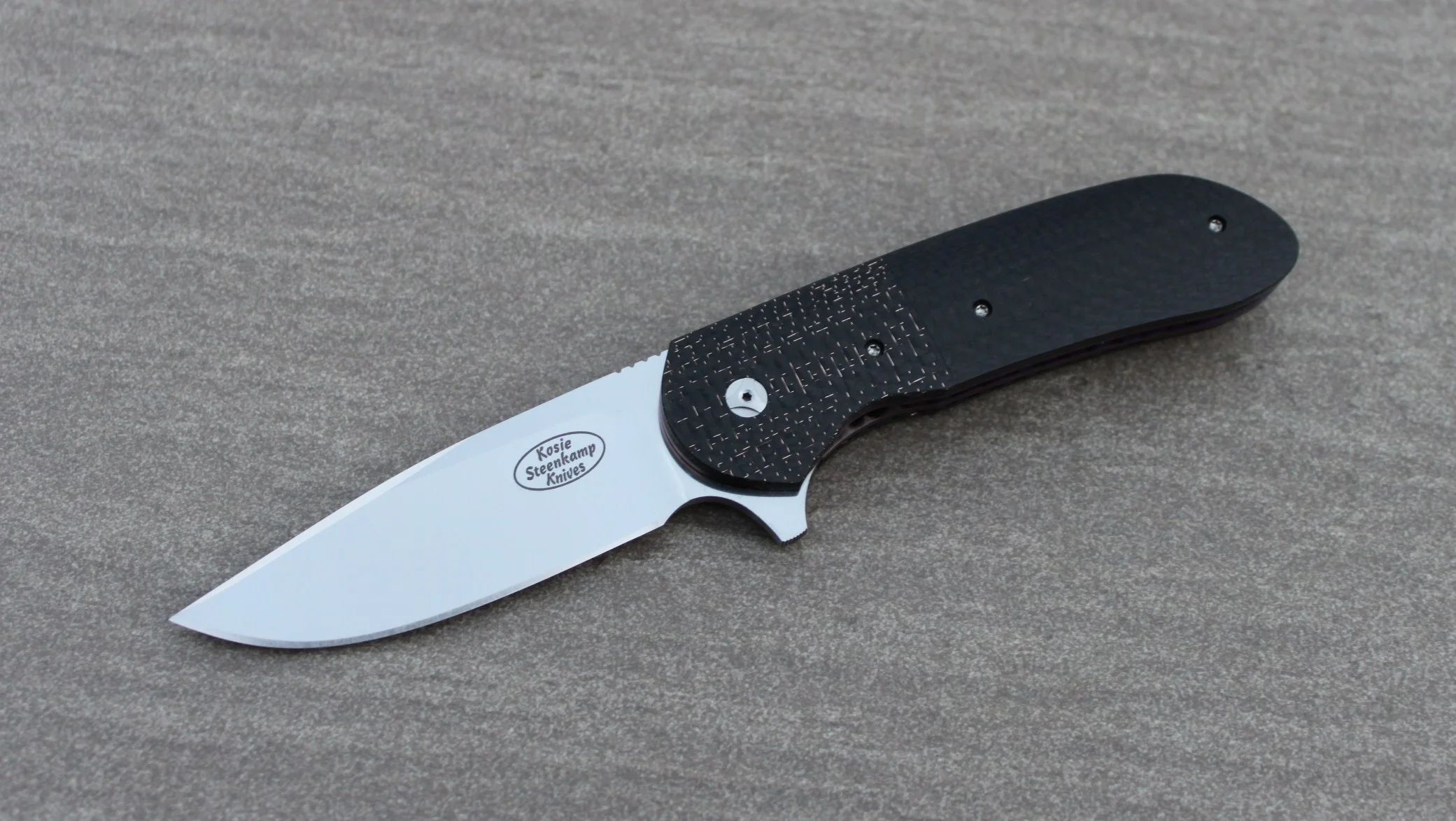 Knife: Piuma Flipper Liner Lock - IKBS. Böhler N690 Stainless Steel blade. Titanium liners with bronze LSCF + black CF handle scales. Titanium belt clip.