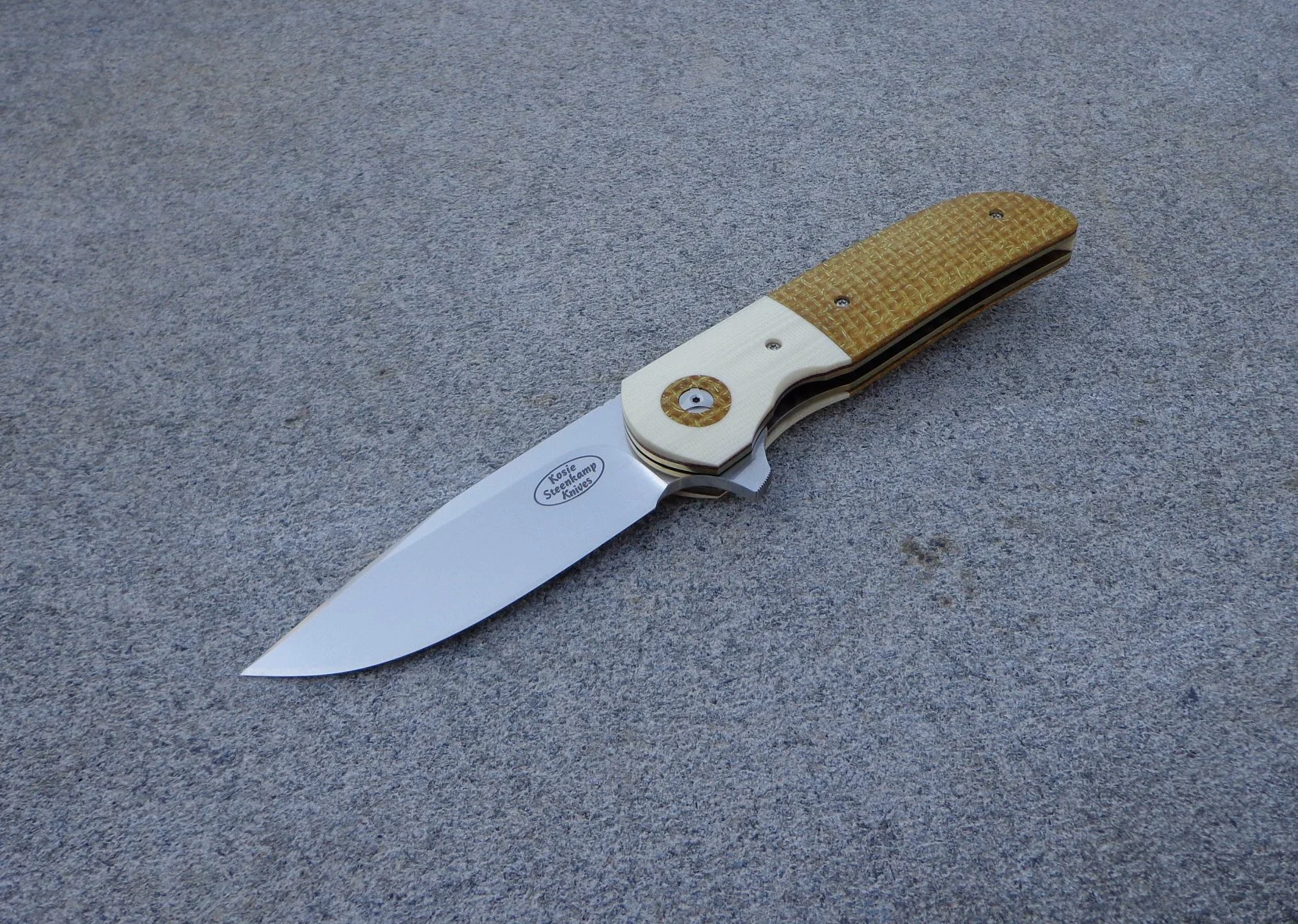 Knife: Majesty Flipper - IKBS. Blade: Böhler N690 Stainless Steel. Liners: Titanium, anodized golden. Handle scales: Kevlar and Ivory G10. Pocket clip: Titanium, machined and anodized golden.