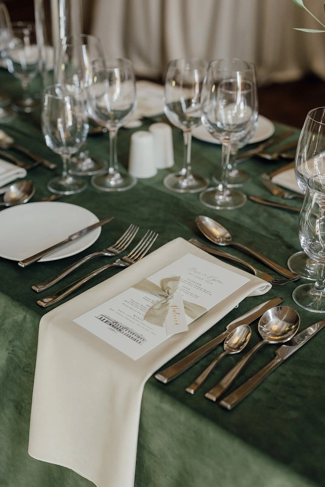 Wedding place setting with green velvet linen, ivory napkin and bespoke menu