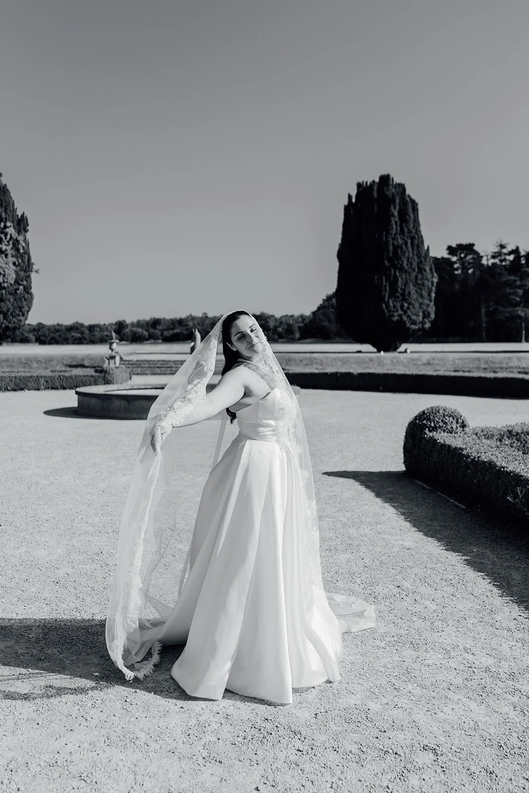 Black and white photo of the bride in the formal gardens at Castlemartyr Resort