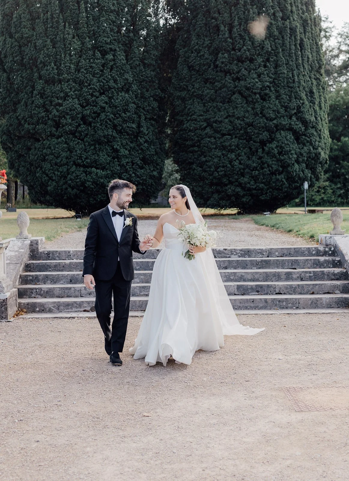 Bride and groom walking down the garden steps together at Castlemartyr Resort
