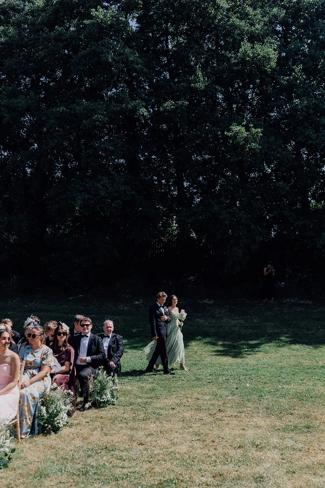 Groomsman and bridesmaid walking down the aisle at the outdoor ceremony