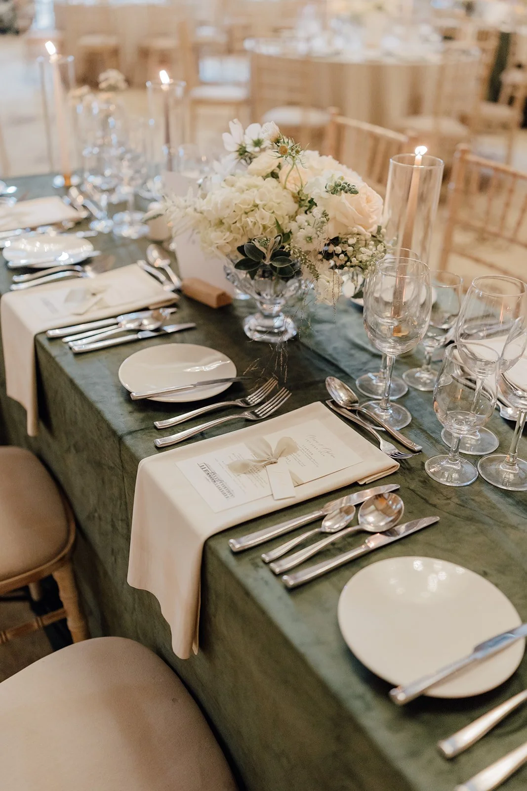 Long table with white florals, glassware and ivory napkins, styled by Amy Daunt Events
