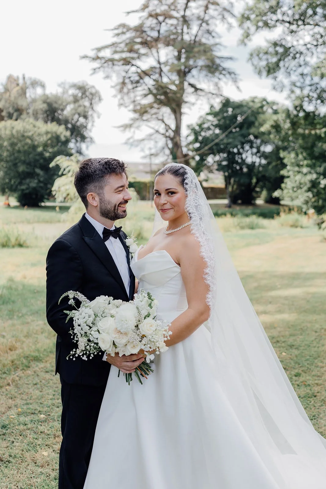 Bride and groom portrait with her white bouquet in the grounds of Castlemartyr Resort