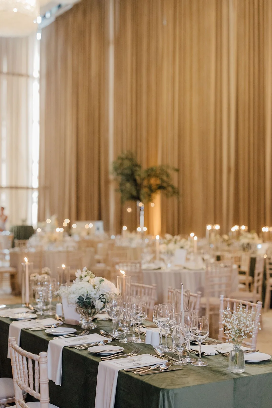 Round reception tables with candlelight and white florals at Castlemartyr Resort