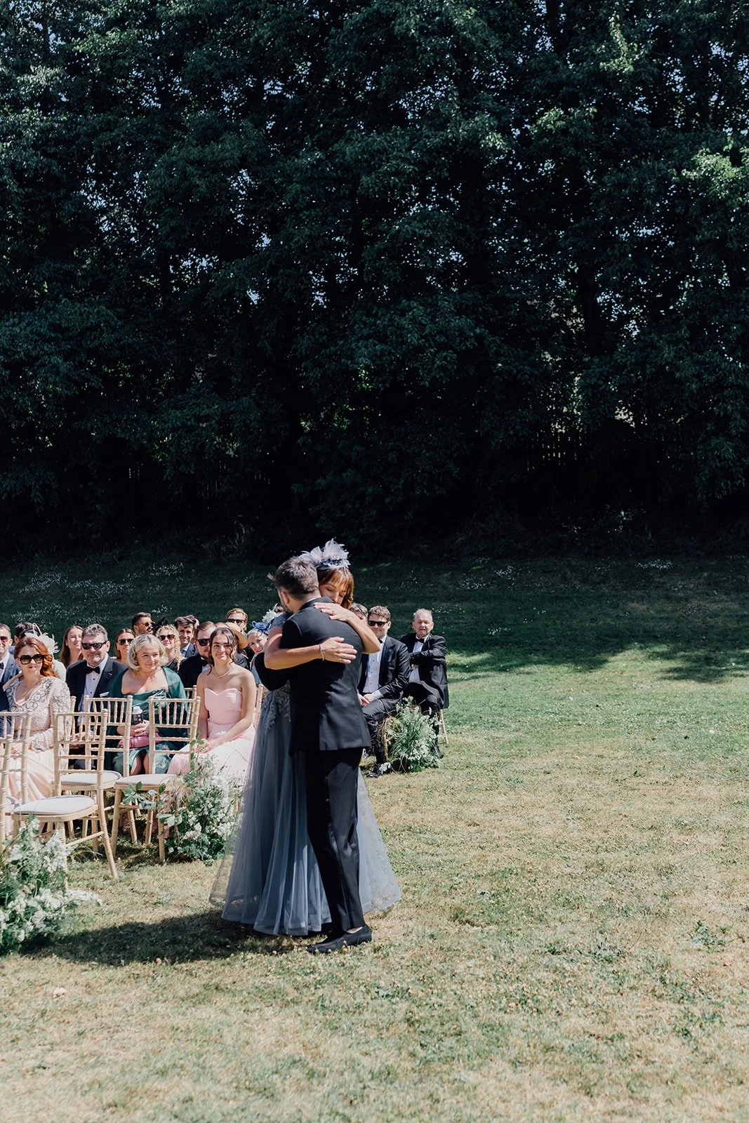 Groom hugging his mother at the end of the aisle