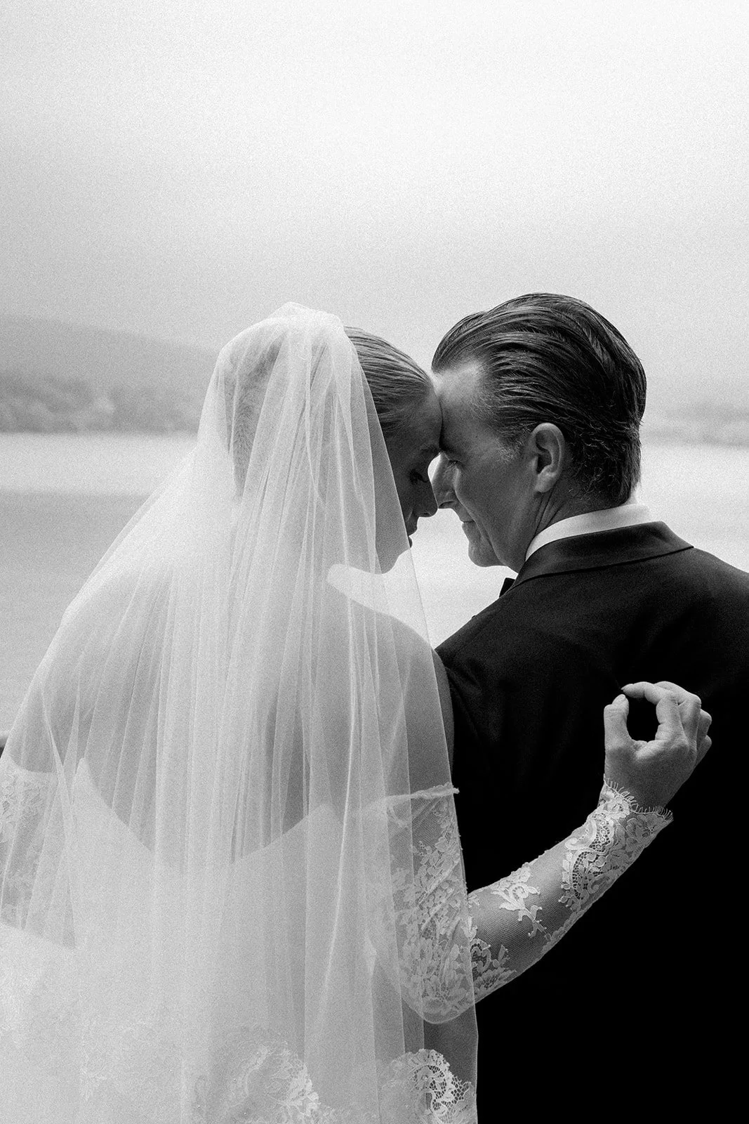 Black and white photo of a bride and groom holding each other with foreheads touching, at Sheen Falls Lodge Kenmare