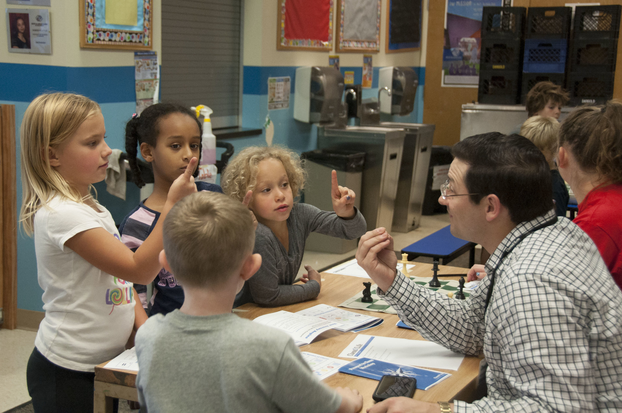 Elliott Neff teaching Boys & Girls Club children how to play chess- Fall 2016. Photo by Sarah Smoots.JPG