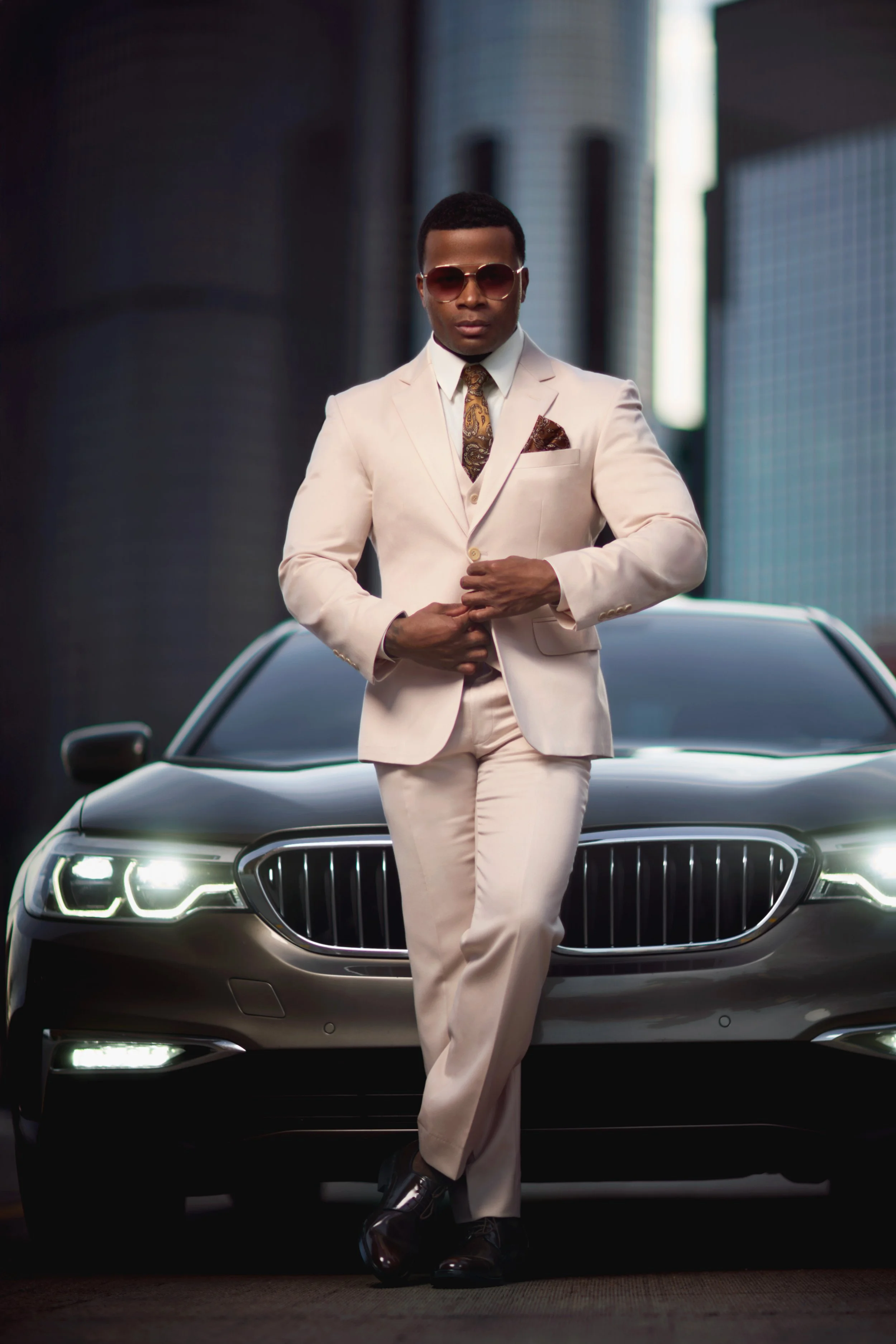 A portrait of a well-dressed man with a BMW at Detroit's Renaissance Center