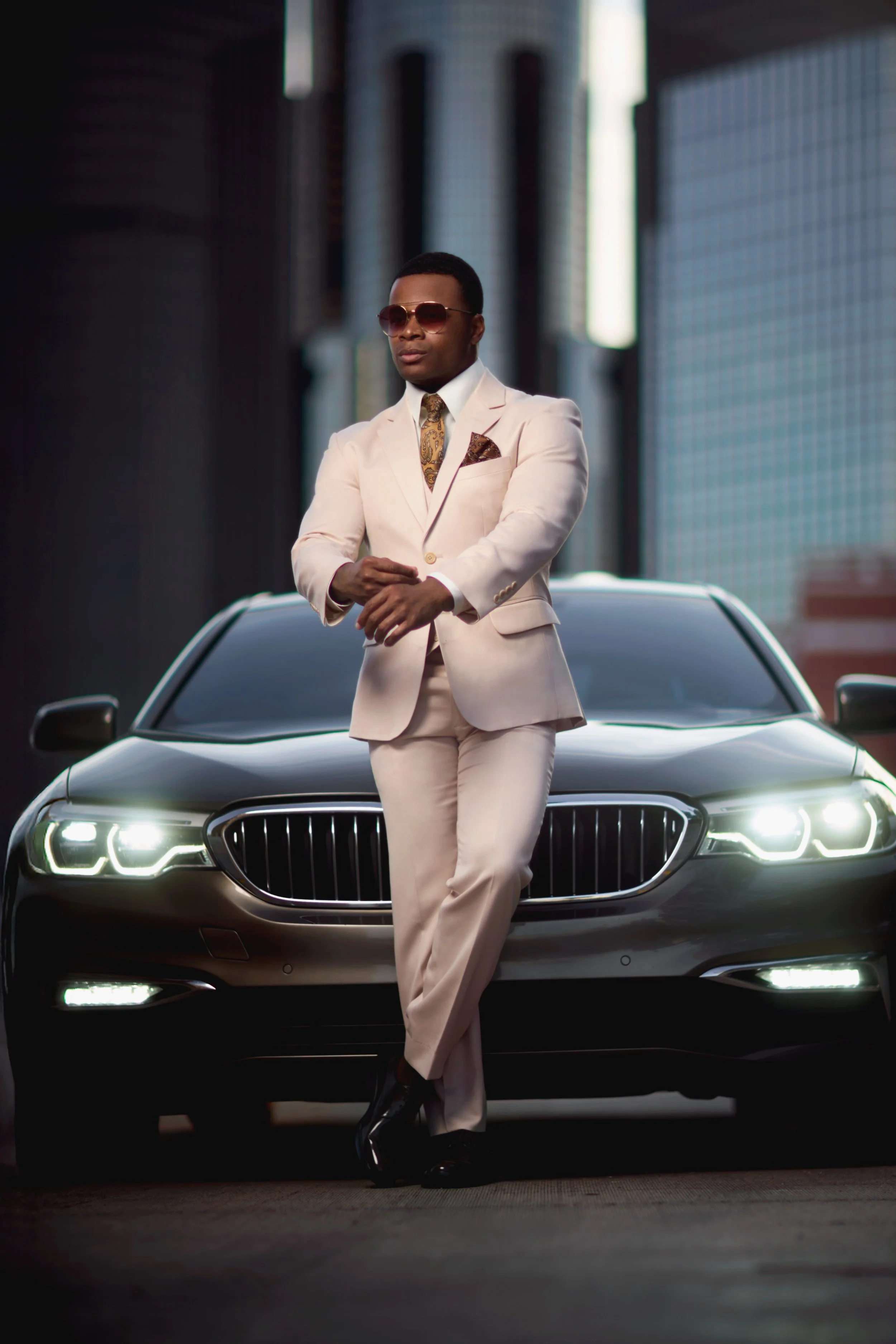A portrait of a well-dressed man with a BMW at Detroit's Renaissance Center