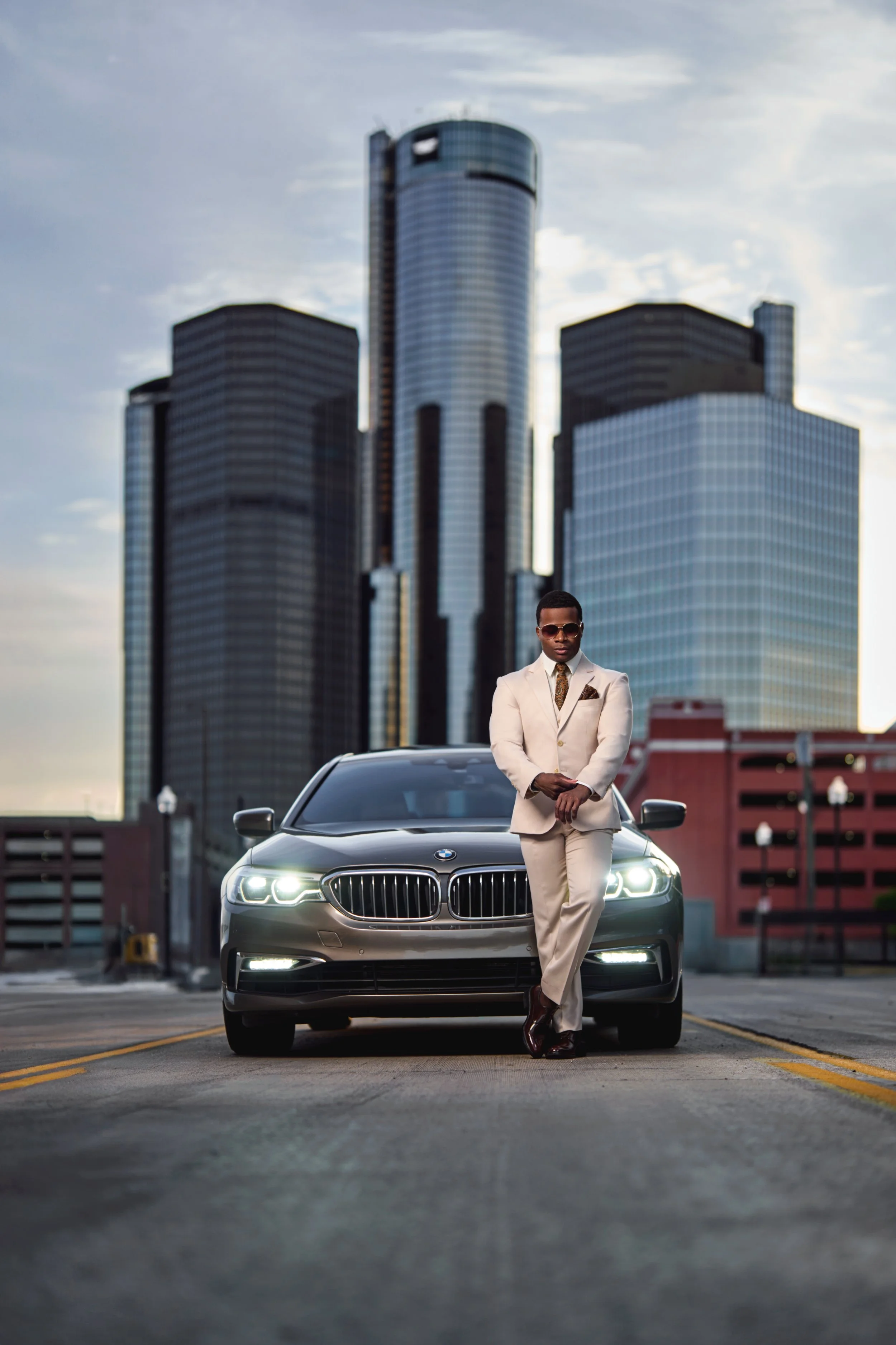 A portrait of a well-dressed man with a BMW at Detroit's Renaissance Center