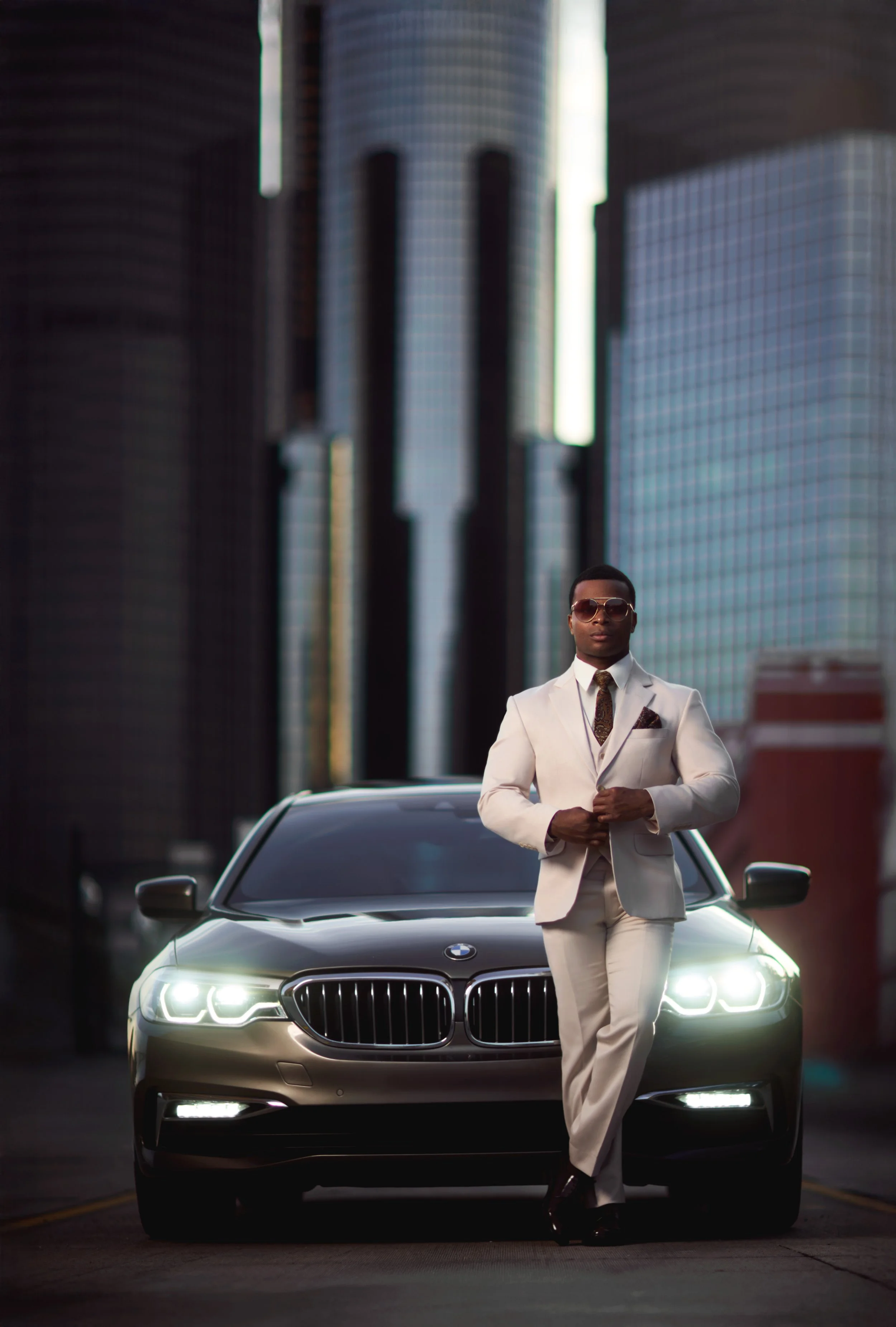 A portrait of a well-dressed man with a BMW at Detroit's Renaissance Center