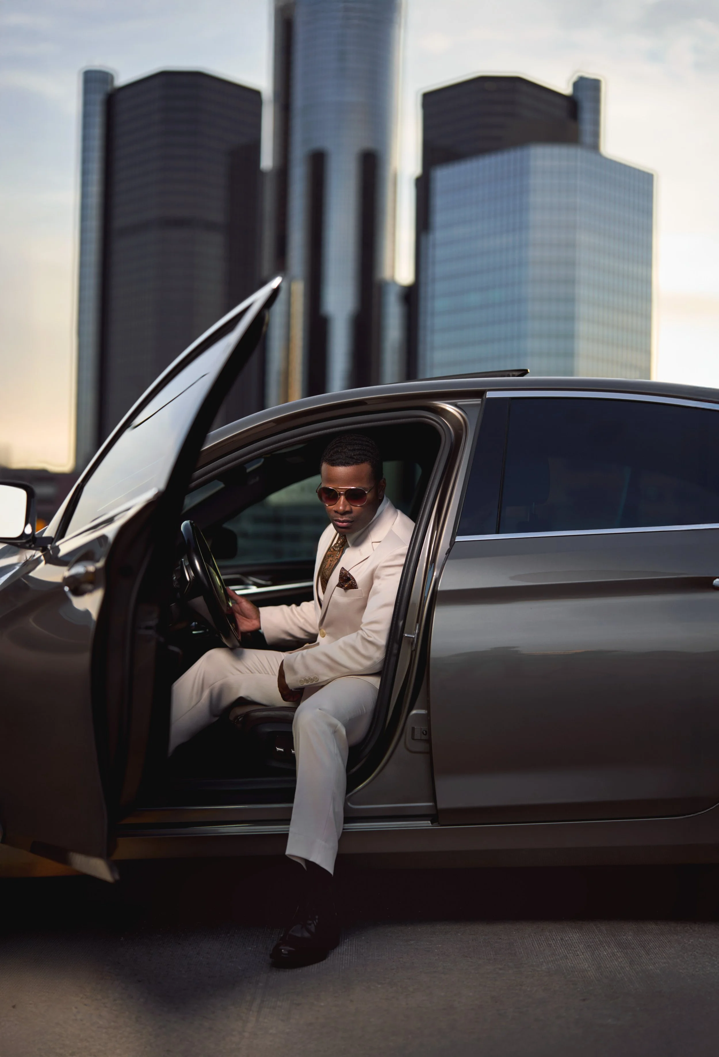 A portrait of a well-dressed man with a BMW at Detroit's Renaissance Center