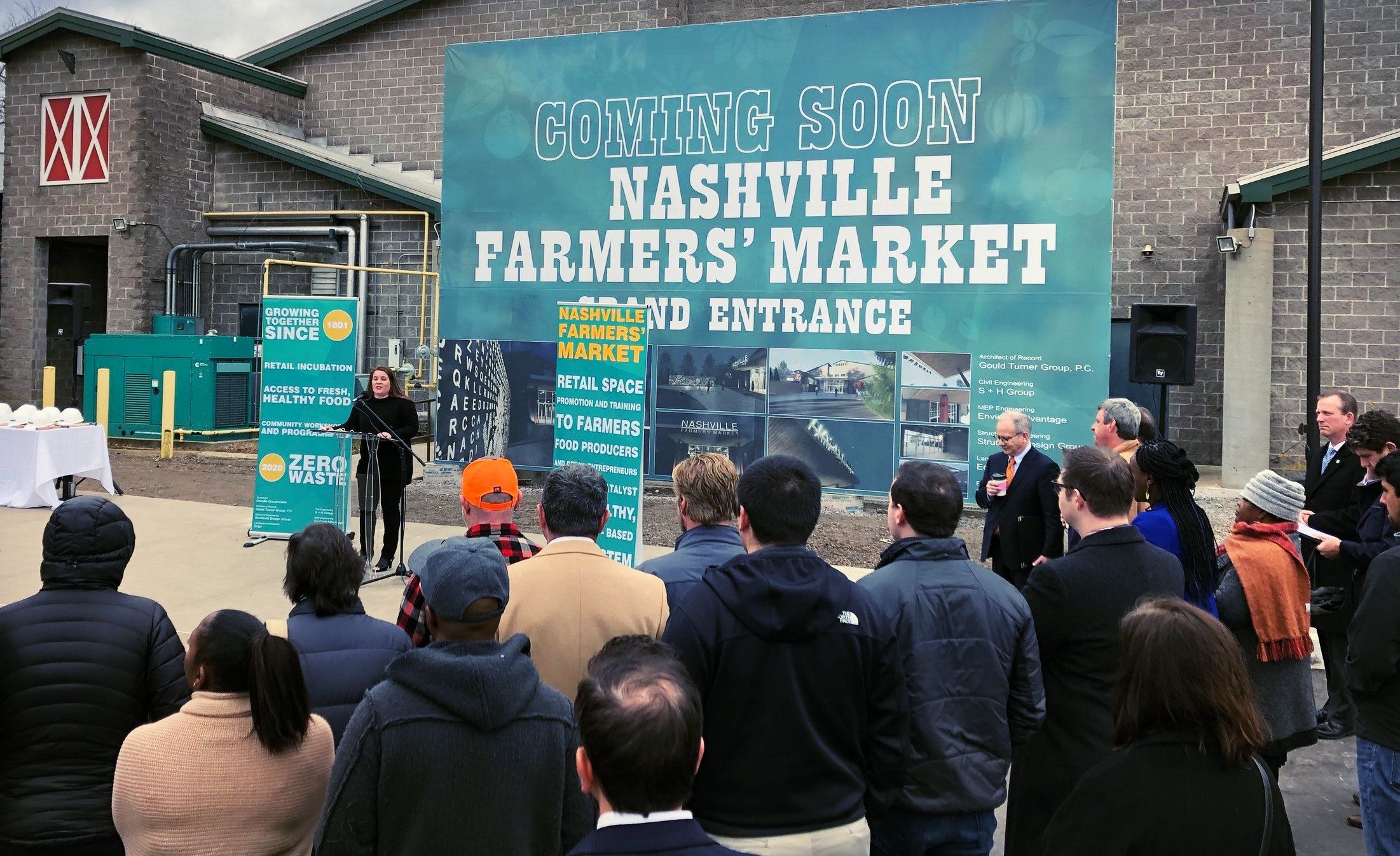 “Just like the entrepreneurs that operate here, the Market has and continues to be resilient and innovative,” Tasha Kennard, executive director of the Nashville Farmers’ Market, told the crowd at this morning’s event that kicked off a major renovation project. “This is an exciting time at the Market and we gather today to celebrate upcoming renovations and share our efforts to support more farmers, artisans and small businesses in our community.” Nashville Mayor David Briley waits for his chance to speak just right of center.