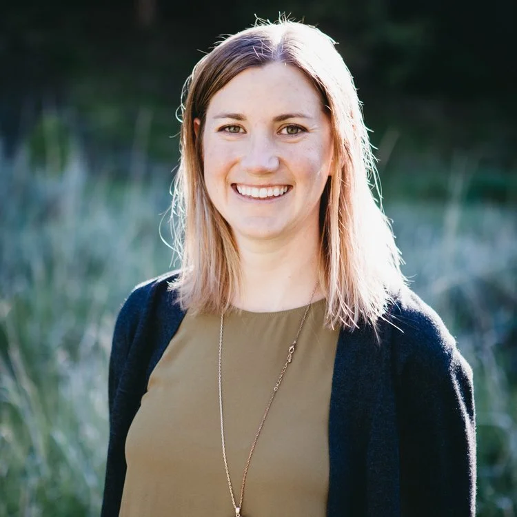 Dr. Mollie Smiling outdoors wearing a green top and dark cardigan