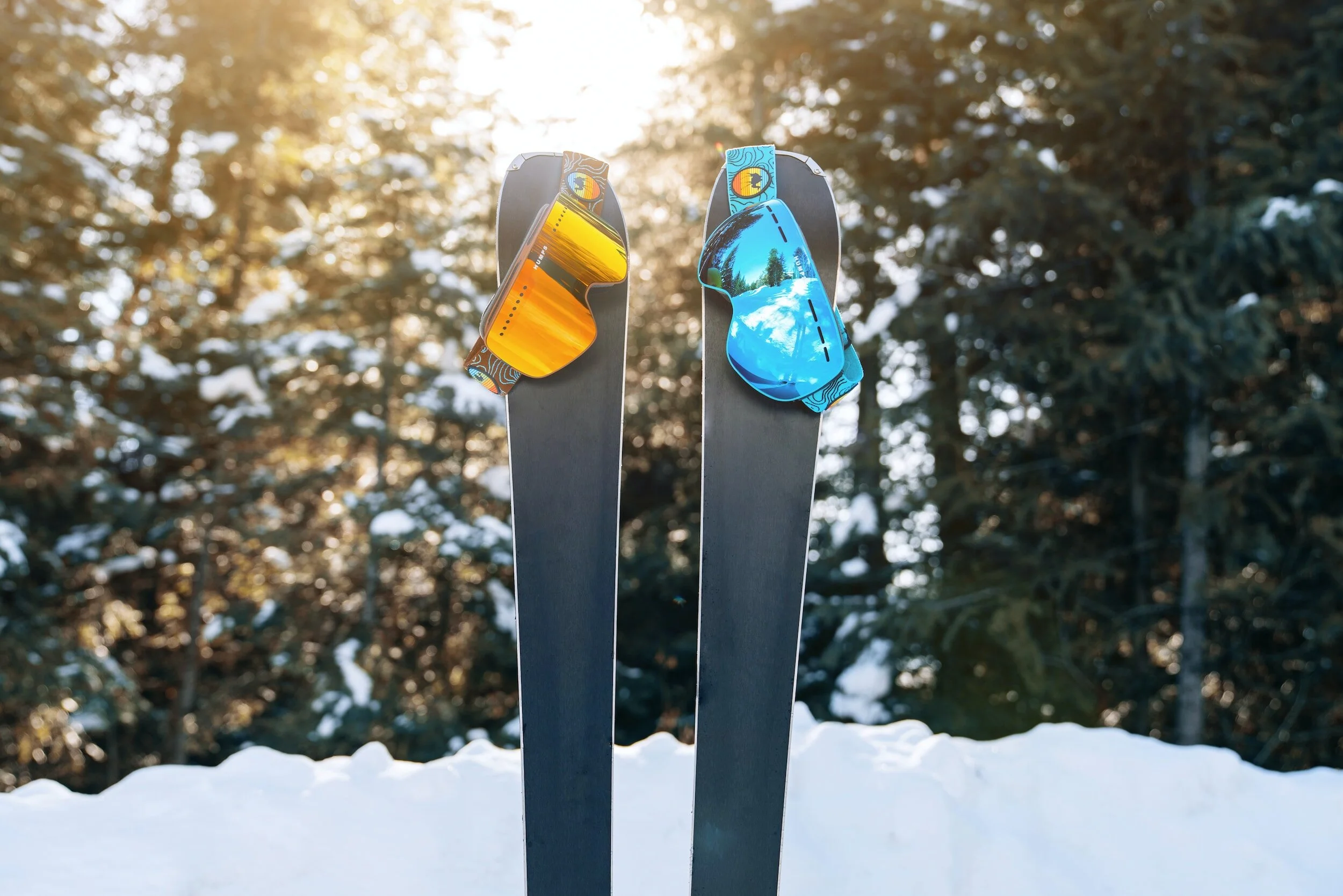 A pair of skis with goggles hanging off of them