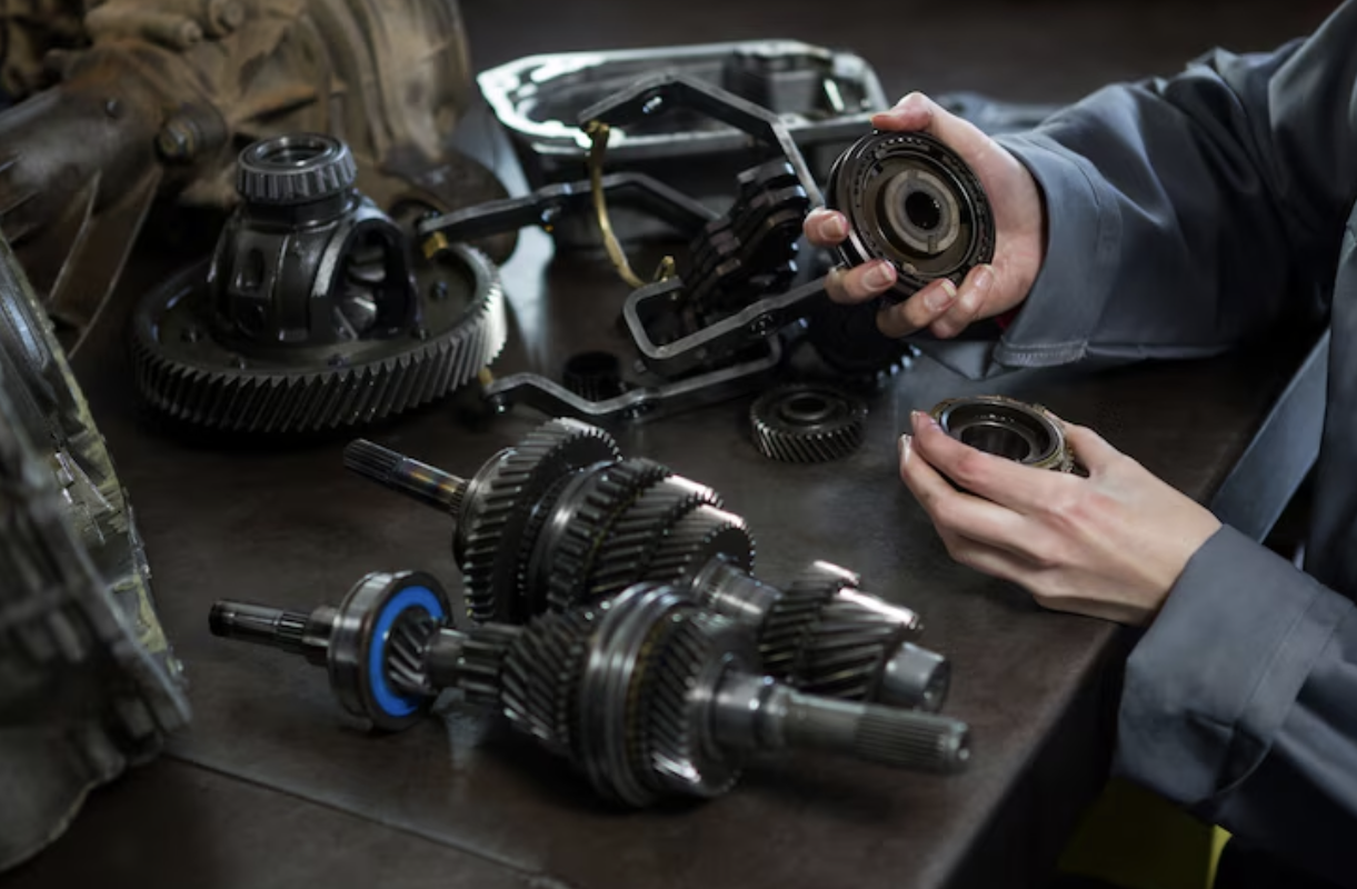 A guy holding an engine part of a car