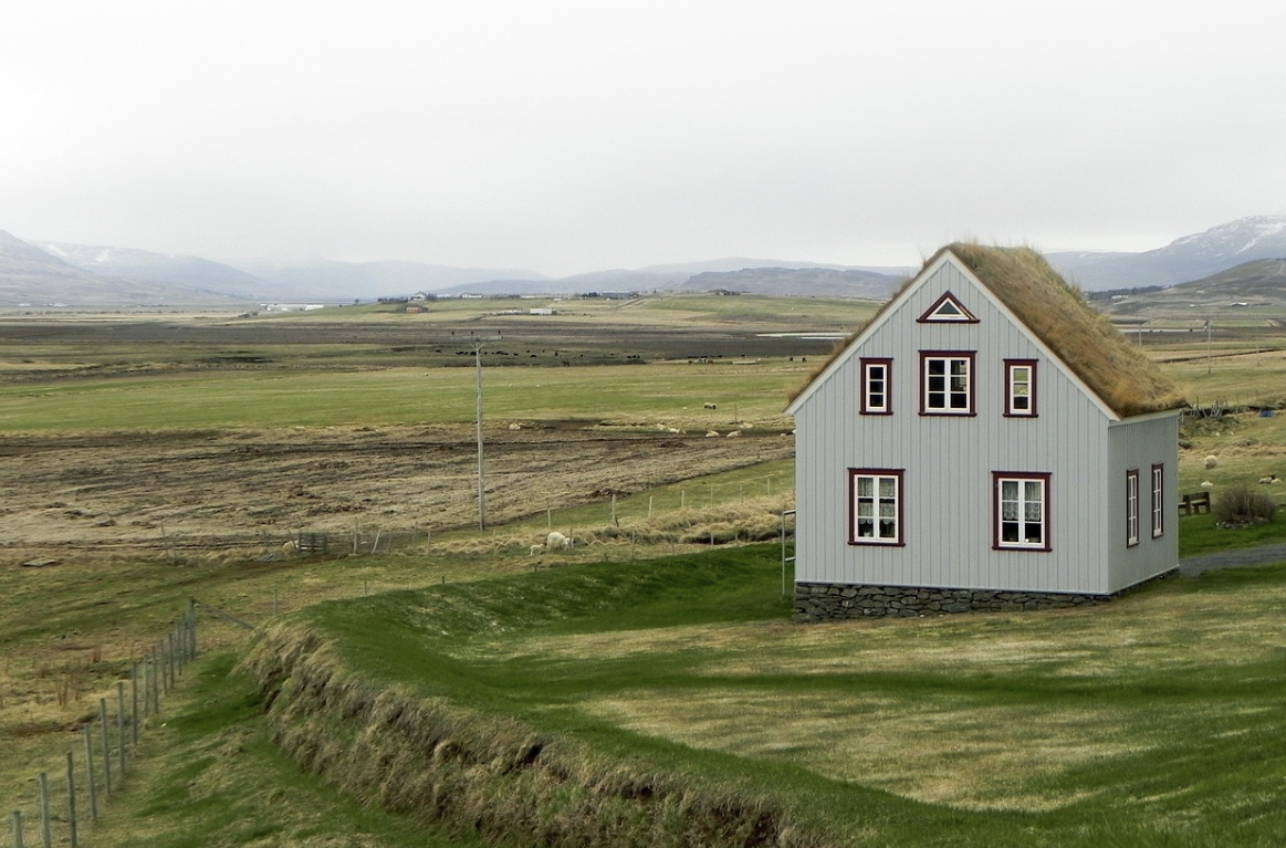 a lone farm house in the middle of a field