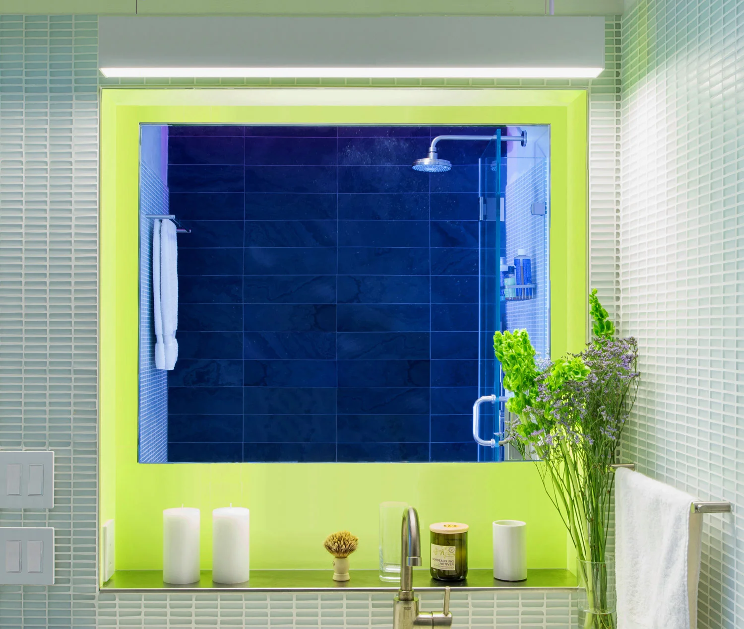 New York Apartment Renovation - Bathroom view 1 - The bathroom wall niche incorporates a "floating" mirror and a stainless steel shelf. A linear pendant lights the vanity top.