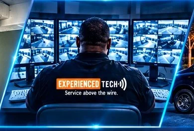 Experienced Tech technician viewing surveillance camera feeds on multiple monitors.