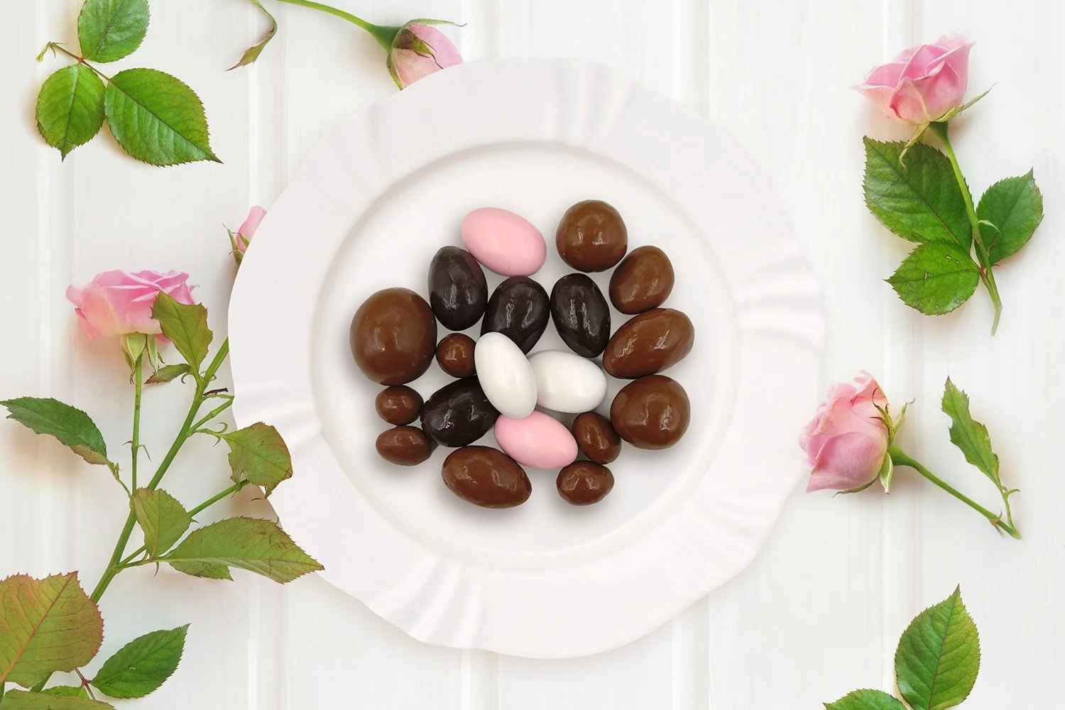 chocolate mix on white plate on white timber surface with pink roses around it