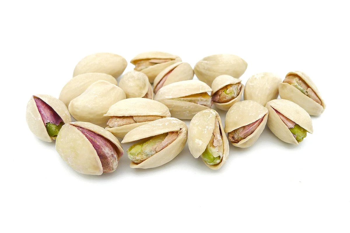 Salted pistachios with shells on white background
