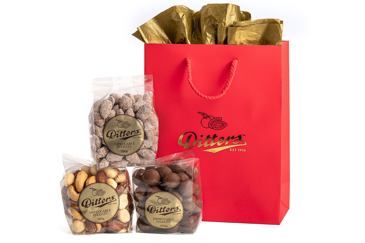 ditters gift bag filled with champion's mix, cinnamon almonds and milk chocolate hazelnuts in a red gift bag