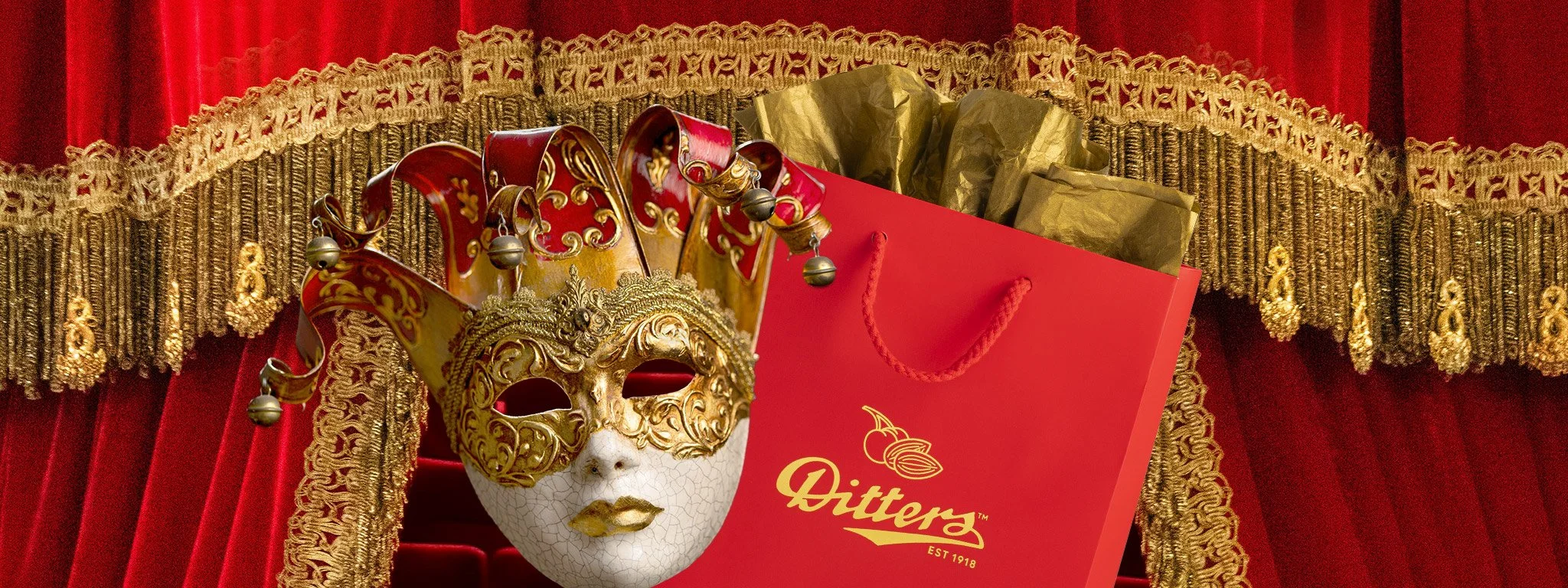 gold trimmed red velvet stage curtan with drama theatre mask and Ditters gift bag in front of it