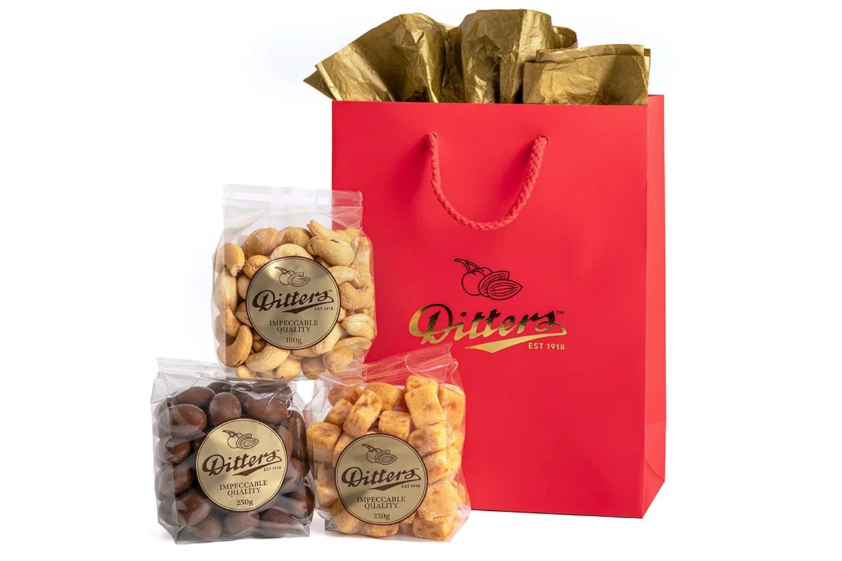 ditters gift bag filled with milk scorched almonds, salted cashews and apricot delight in a red gift bag