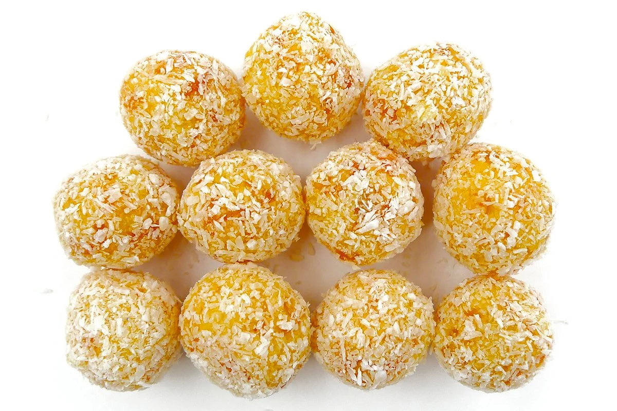 Australian apricot cubes coated in desiccated coconut, isolated on a white background. Bite-sized fruit confection made with dried apricots and coconut.
