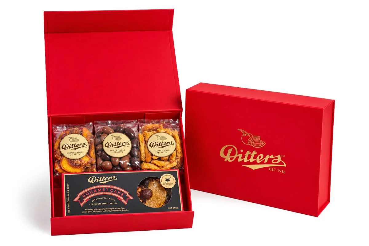 Ditters red gift hamper box containing South Australian dried fruit, Ditters Gourmet Cake and milk and dark scorched almonds