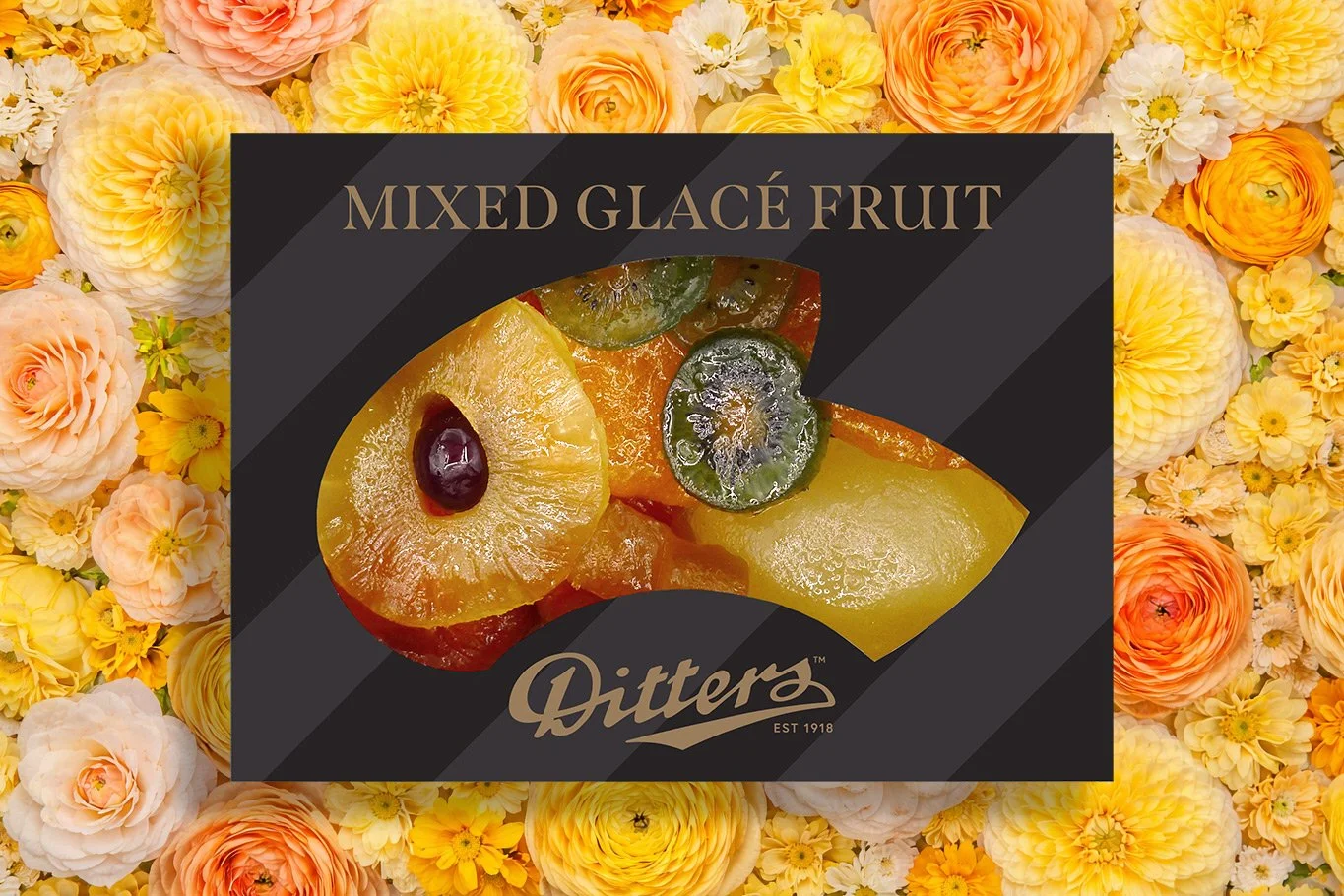 assortment of glace fruit in a black box on a bed of yellow, peach and orange flowers