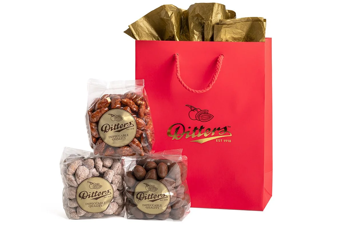 ditters gift bag filled with vienna almonds, milk chocolate hazelnuts and cinnamon almonds in a red gift bag