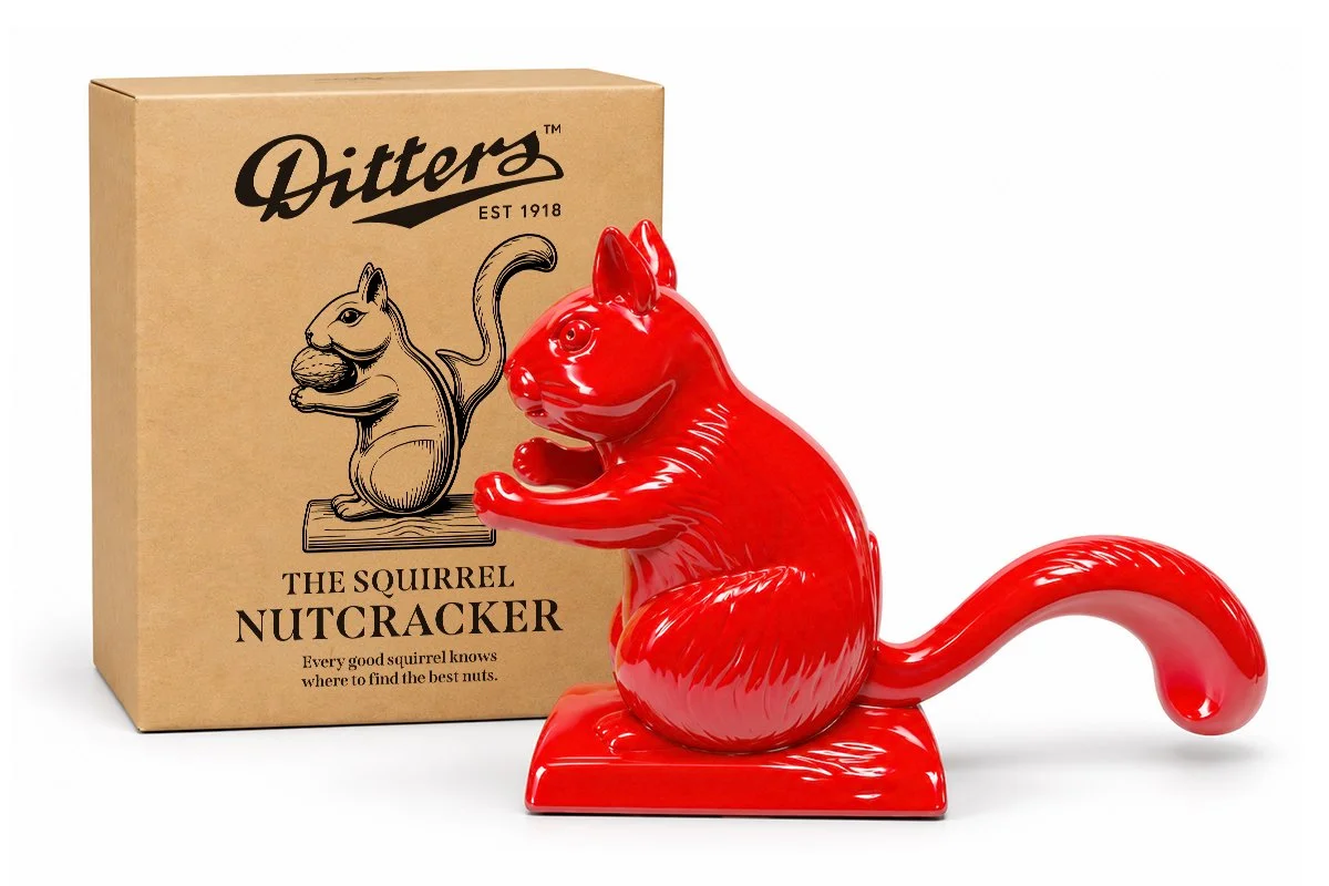 The Ditters Squirrel Nutcracker beside its illustrated gift box, a cast metal nutcracker for almonds and walnuts.