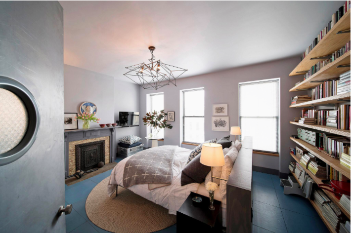 Plywood shelves fill a wall in the master bedroom.