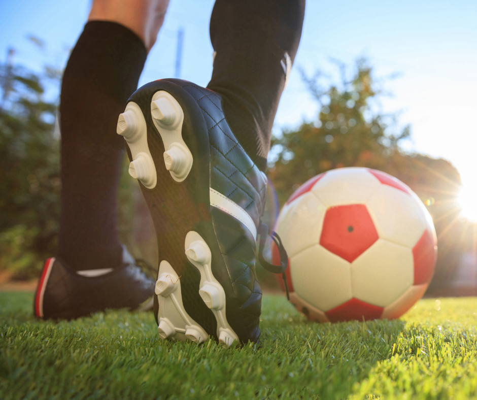 soccer cleats and ball on field