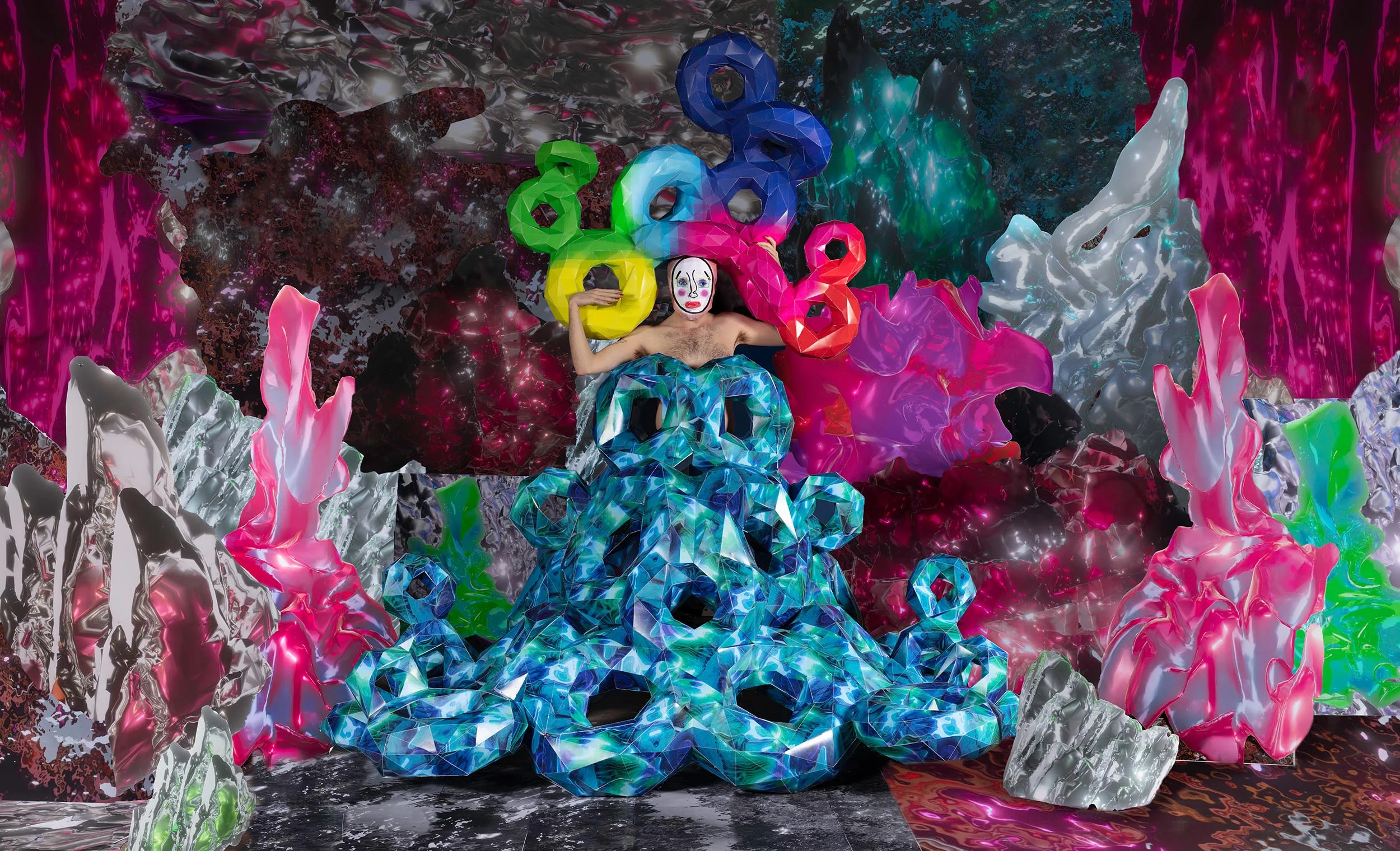 Inspired equally by drag culture and video game aesthetics, “A Slippery Place” touches on themes of identity, embodiment, and fantasy. Through a process of converting digital 3D renderings into paper models, I have constructed drag-influenced costumes, wigs, and masks that they wear for this series of self-portraits. By staging these photographs within sets created from images of video game environments, I am interested in the queering of virtual spaces and blurring the binary of the digital and the physical.