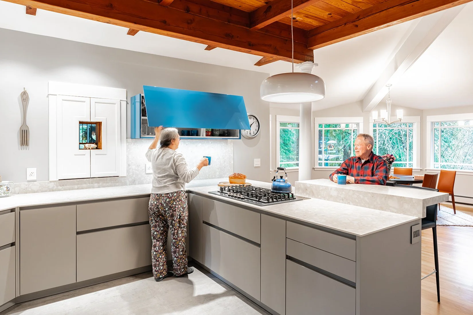 Couple in a luxury kitchen demostrating the work triangle of a kitchen layout design works to improve use.