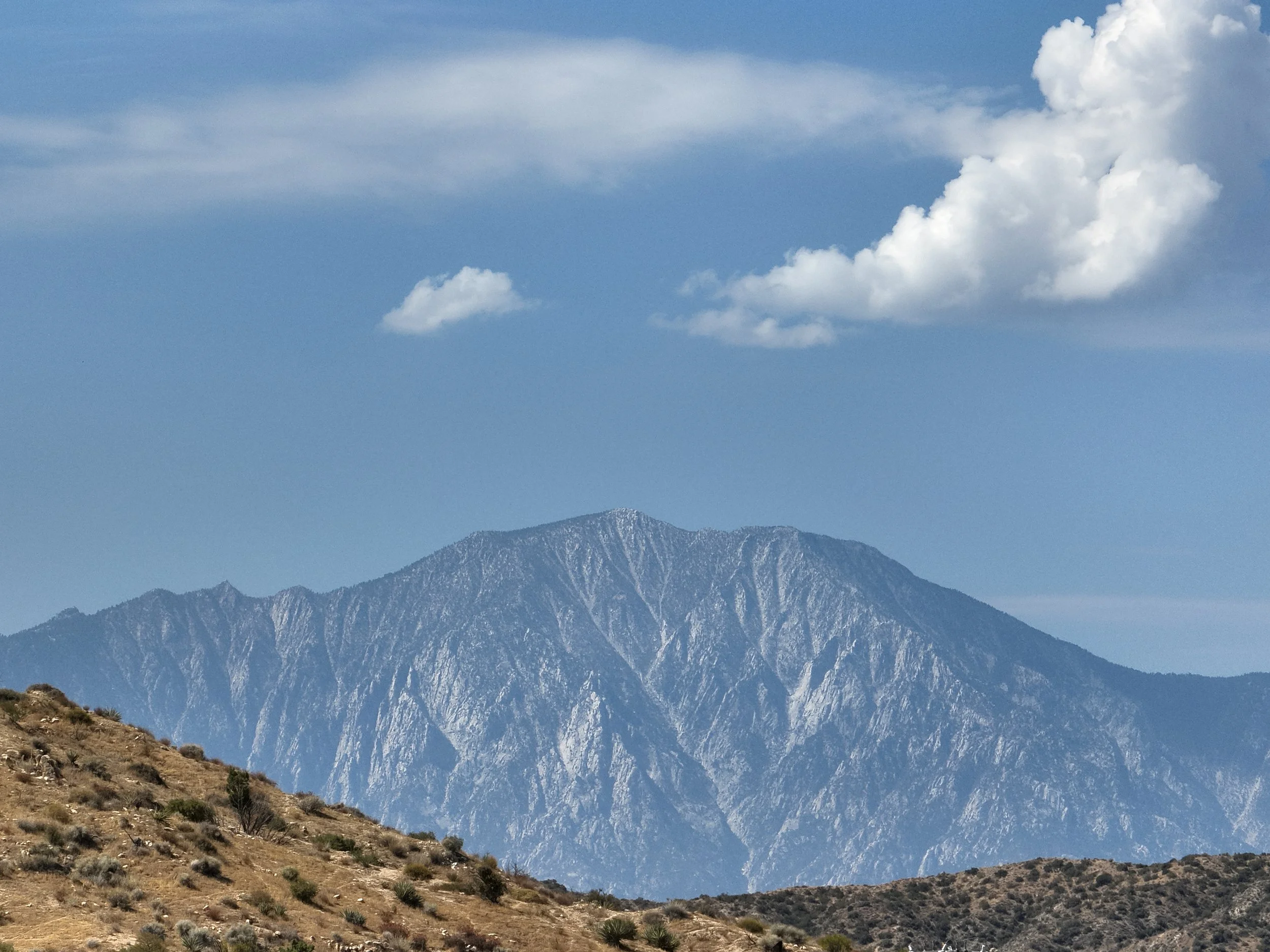 Mt. San Jacinto under a blue sky, seen across the desert hills near Creosote Cottage