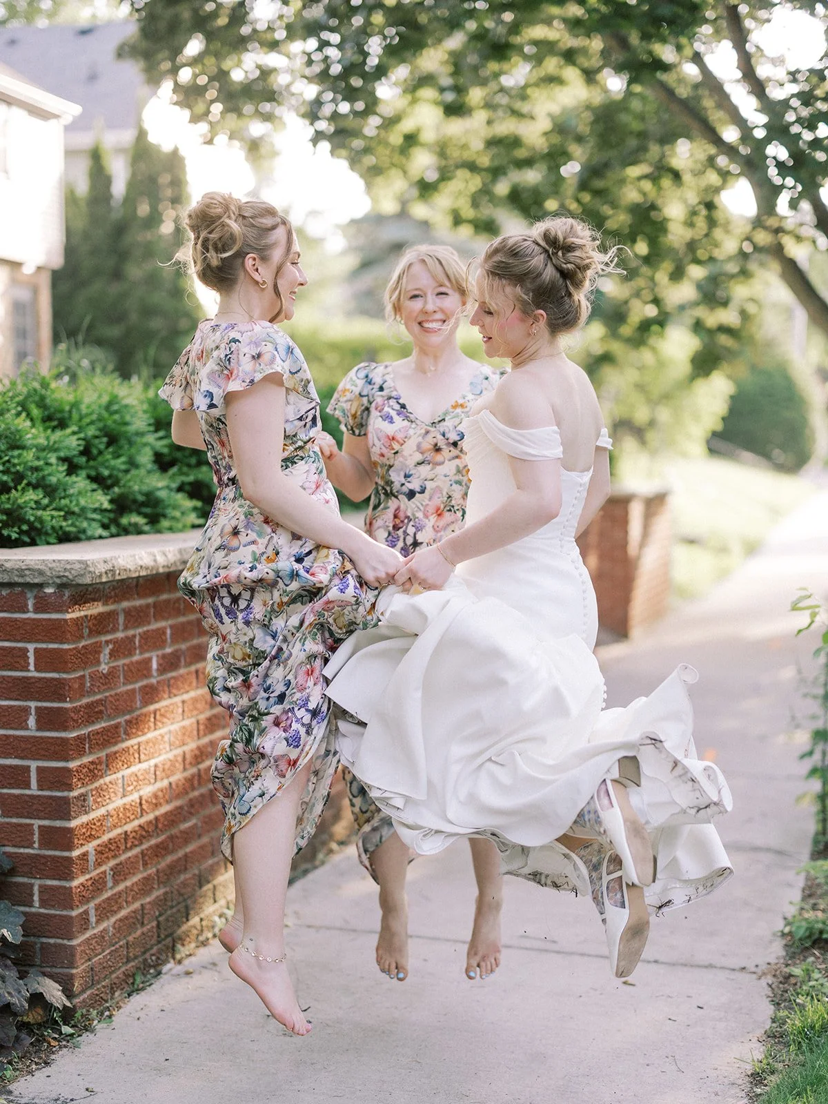 Photo of bride and bridesmaids dancing together in butterfly bridesmaids dresses