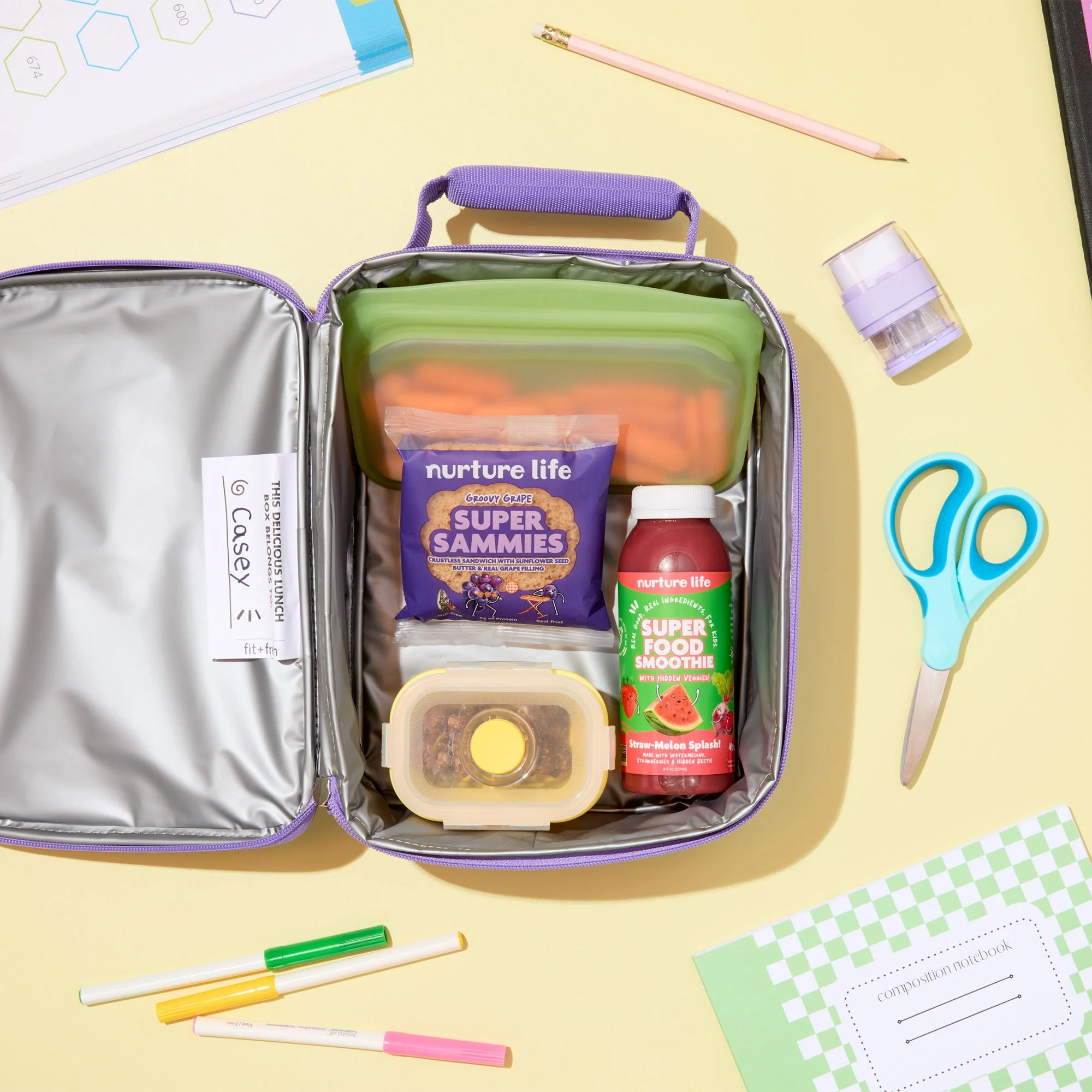 open lunch box surrounded by school supplies