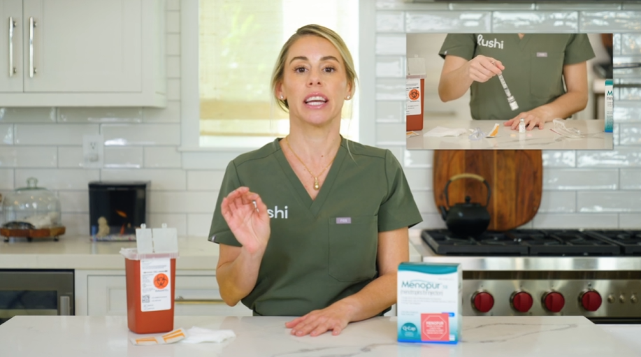 A woman in green medical scrubs giving a tutorial on insulin injection techniques. She is standing at a kitchen counter with diabetes supplies, including a Menopur box, insulin pen, and alcohol swabs.