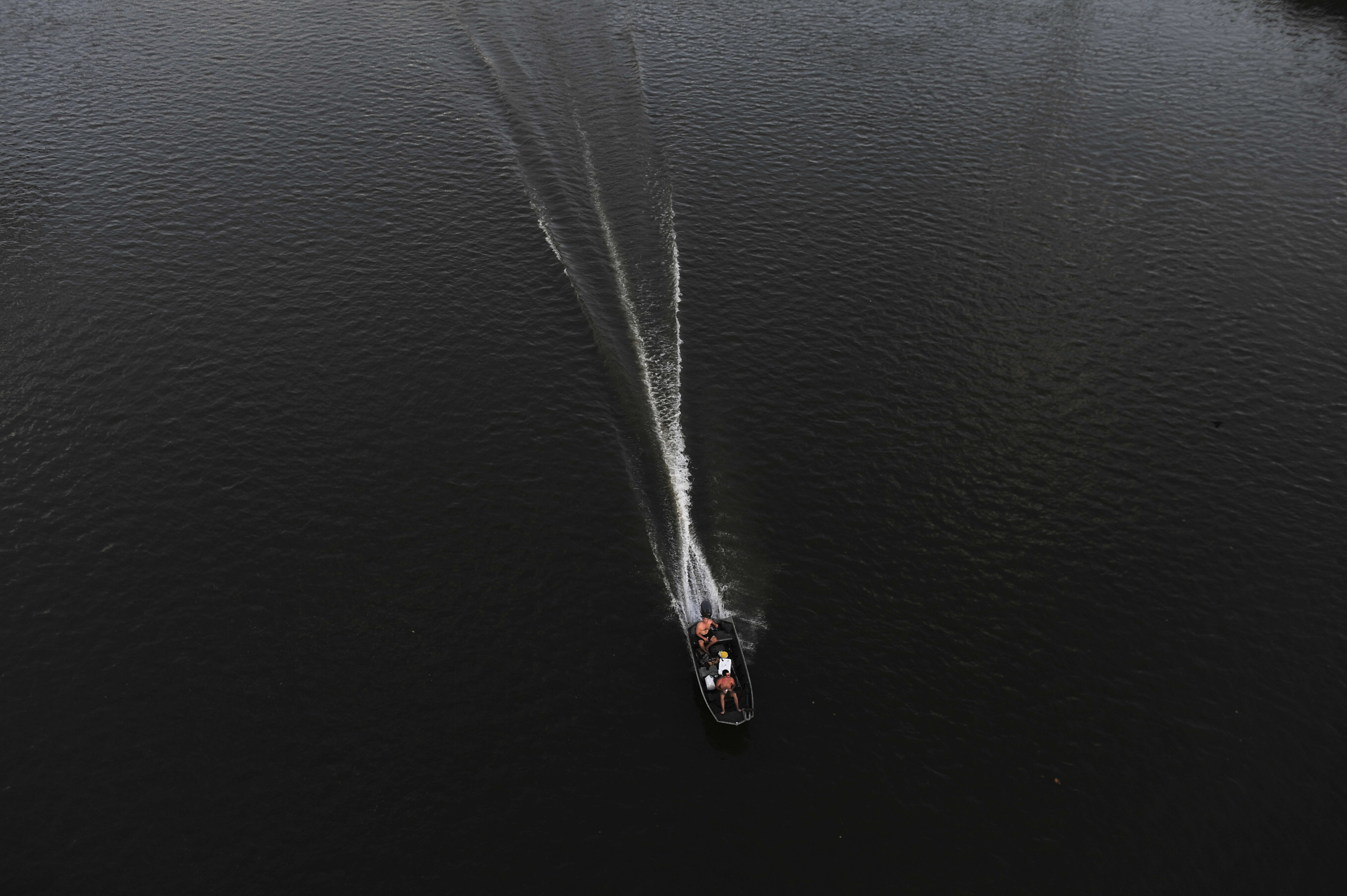  A fishing boat cuts a wake in the dark waters of the Cumberland seen from the Shelby Street Pedestrian Bridge in Nashville, Tenn. 