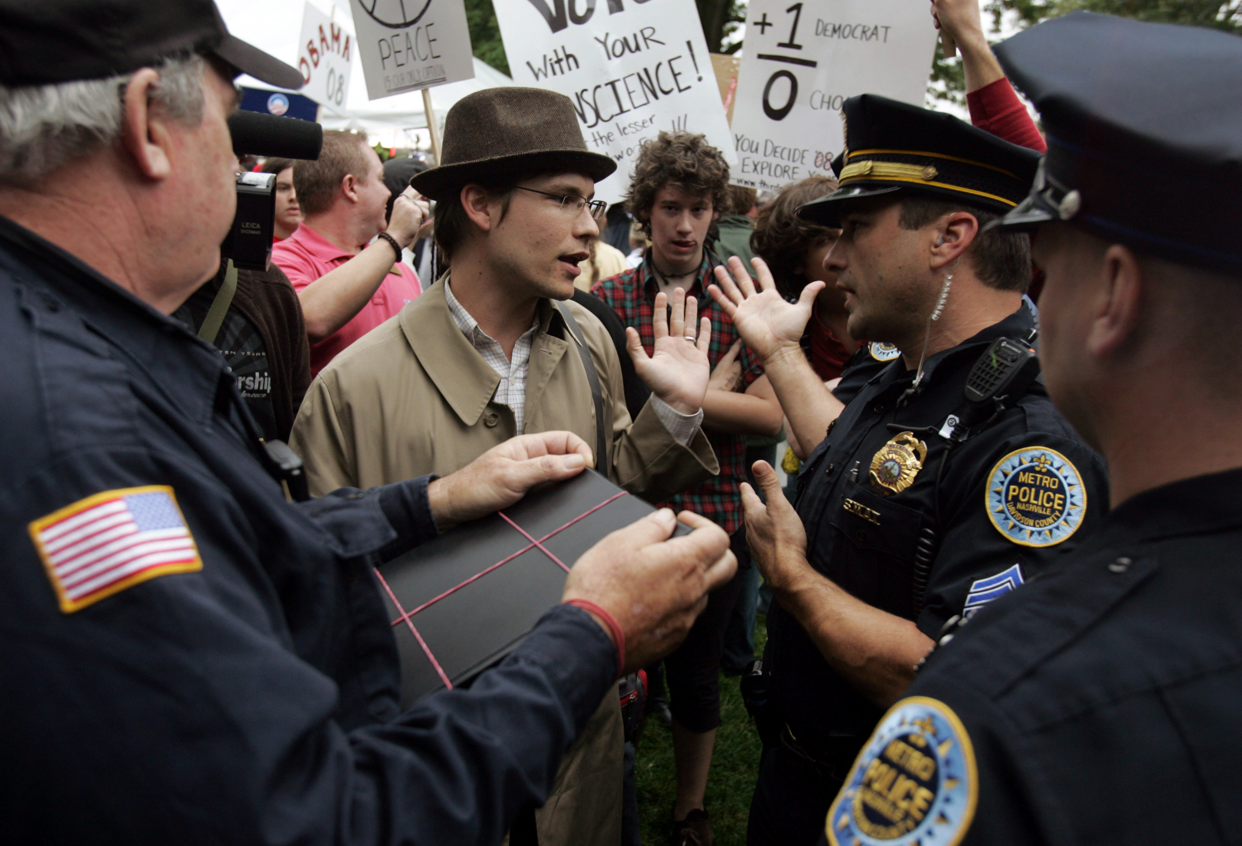  Ben Harms, with Christian Action Against Apathy, argues with security because he refused to show them his ID. Police later escorted the group away from campus but let them protest across the street. The group does not support either candidate, belie