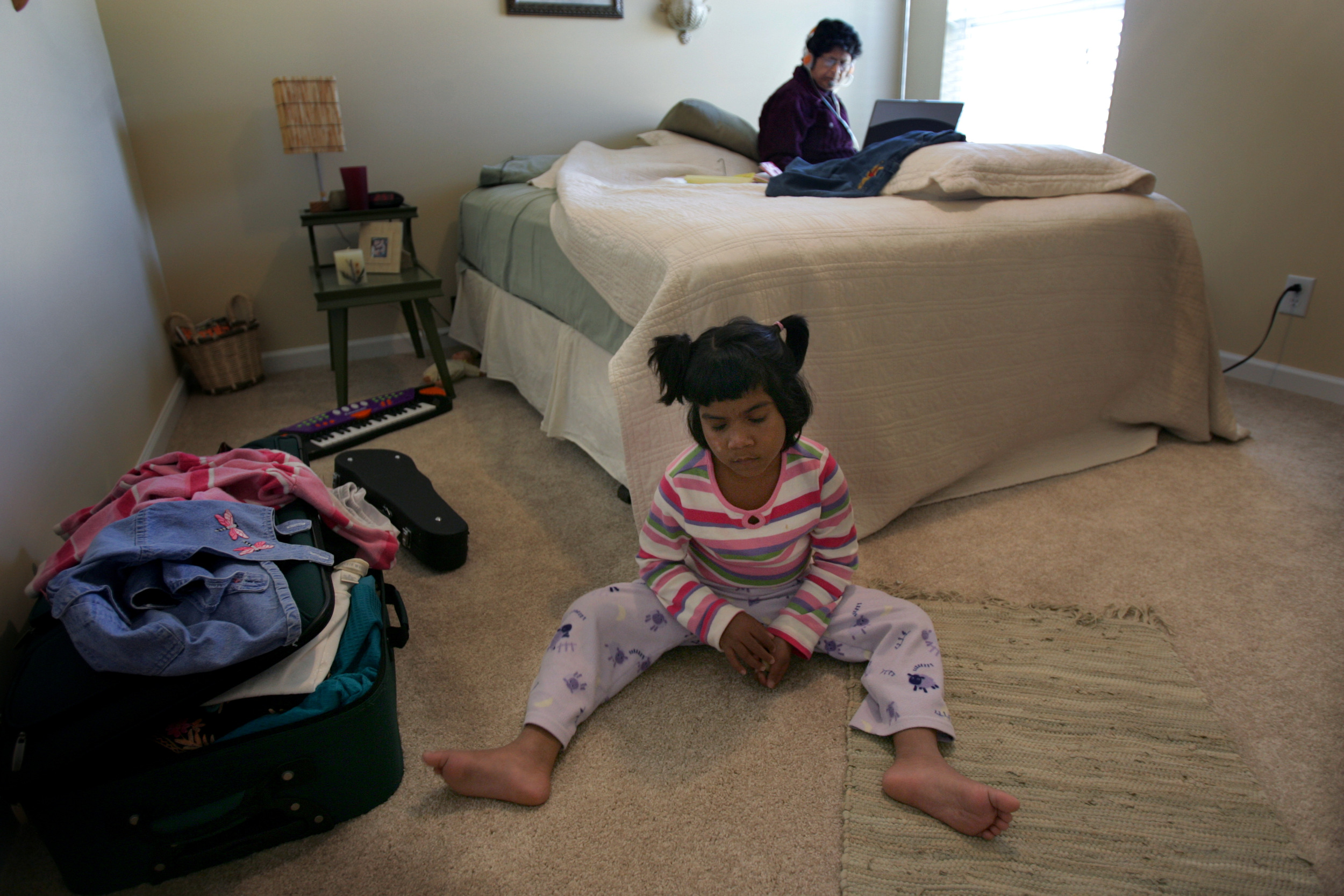 Kajal plays in her room at a new host family's house while guardian Grace Zaidi emails her husband in India November 15, 2007. The Zaidis co-founded S.O.U.P, the Society for Underprivileged People, the organization that rescued Kajal.  