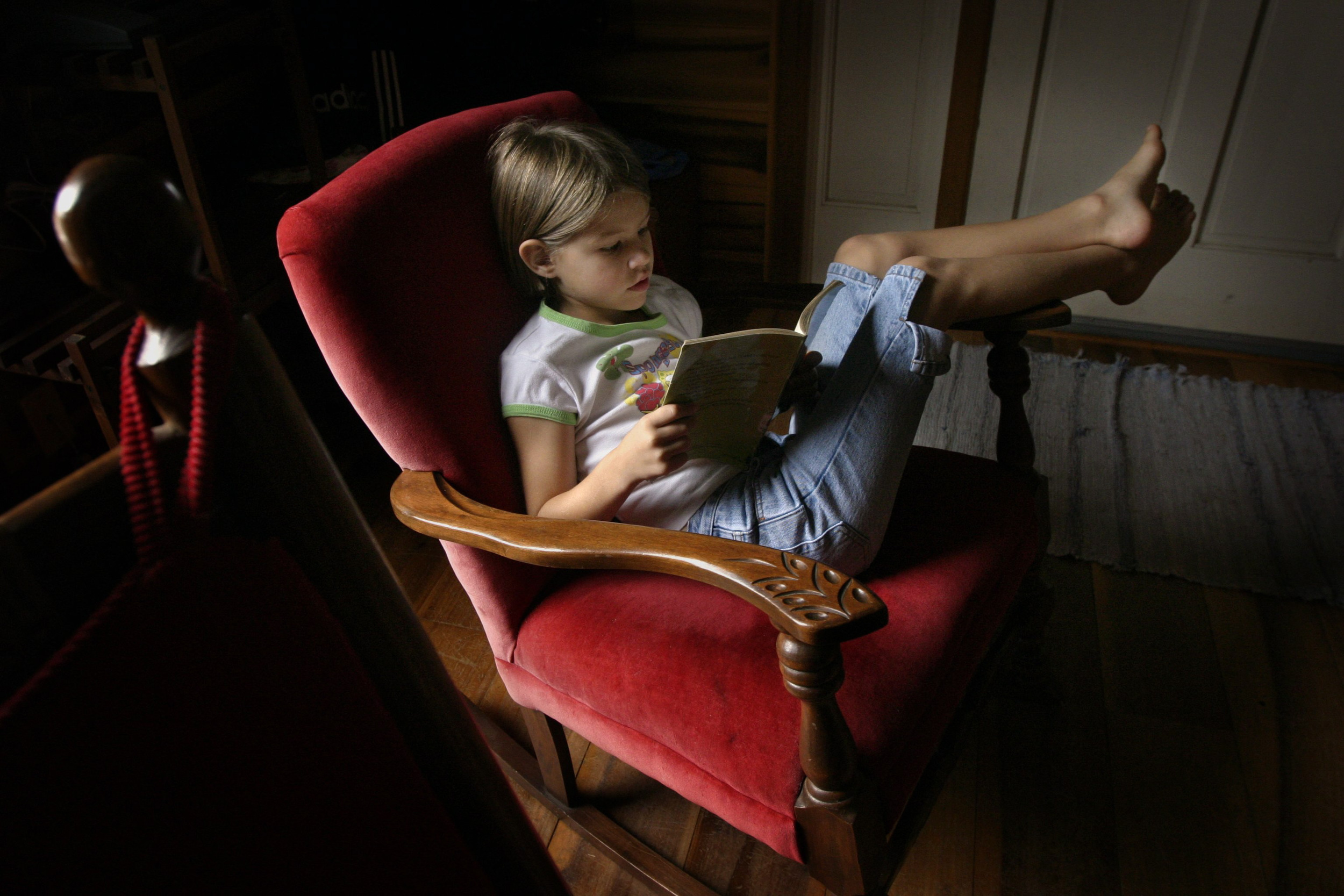  Anna Stewart Burdette, 7, lounges in a comfortable chair near the window during reading time, a part of her homeschool day. 