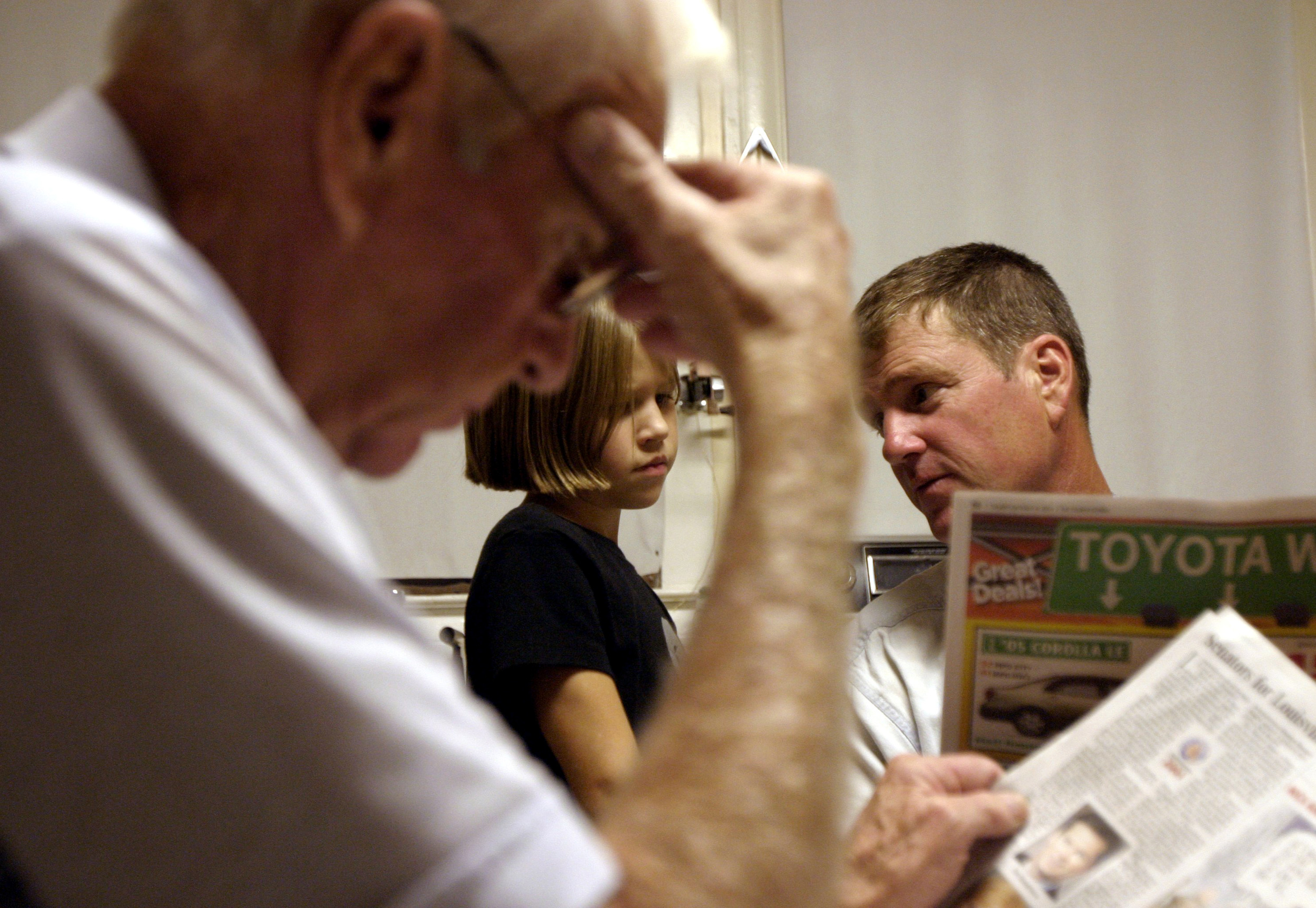  Father Pat Burdette and daughter Anna Stewart, 7, have a disagreement on when she can watch the movie 'Ella Enchanted' as her grandfather reads the paper after dinner. 