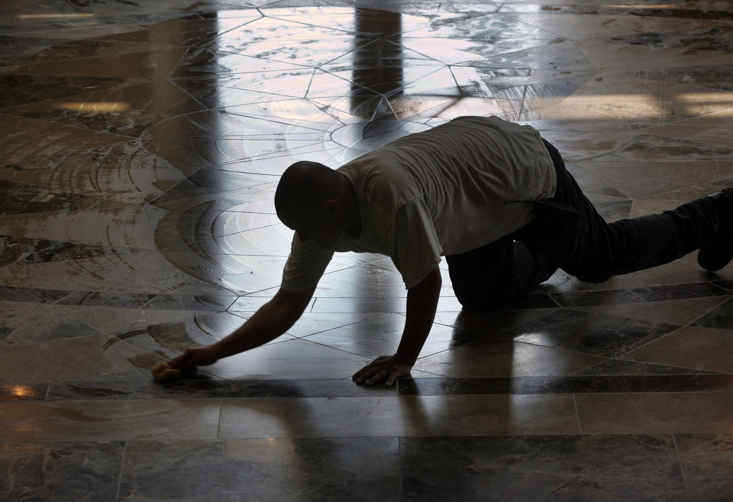  A worker wipes down the entrance floor, made from Spanish marble cut in Italy. The design is based on Michelangelo's design at the Piazza del Campidoglio. 
