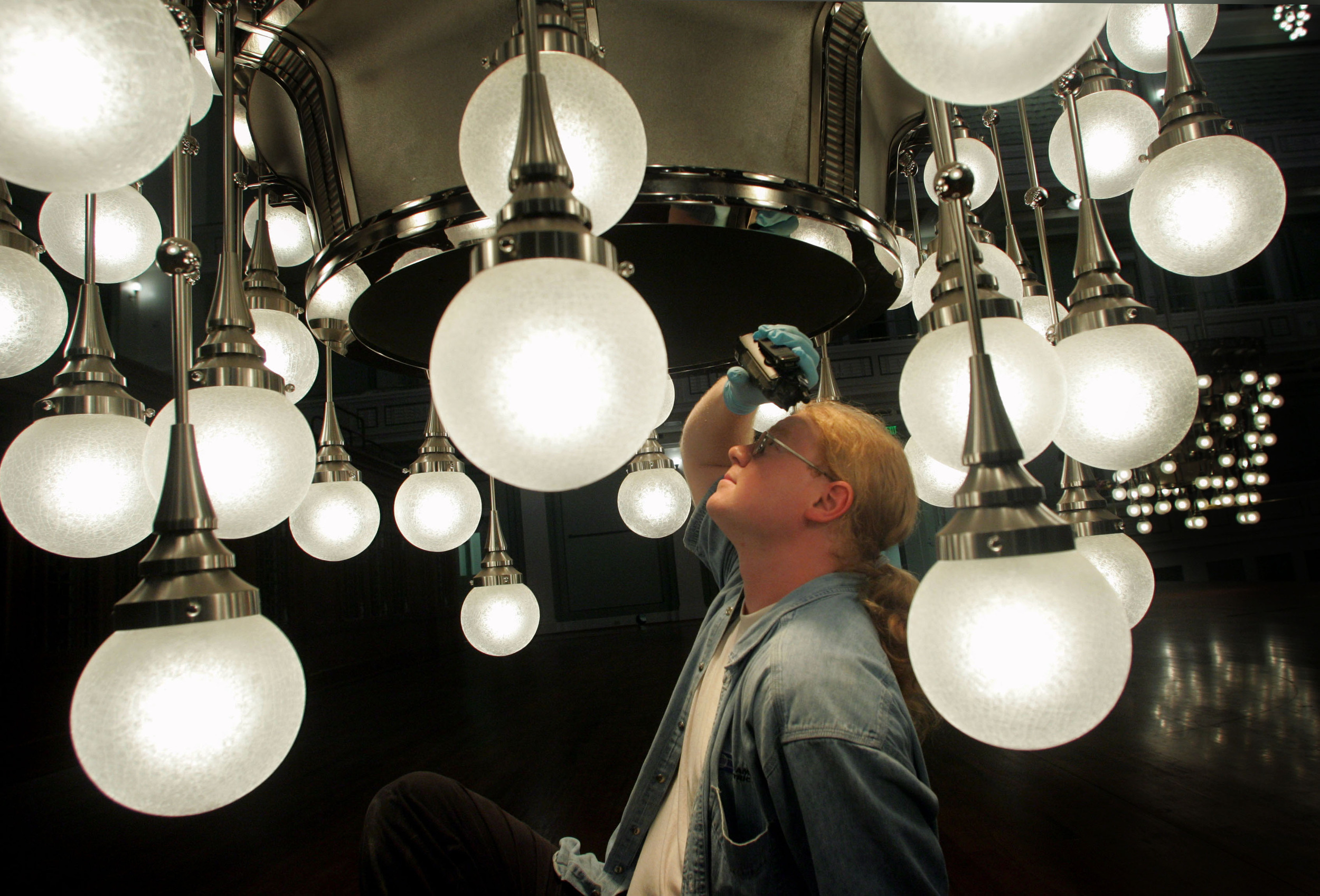  The neoclassical Schermerhorn Symphony Center opened in 2006 and was built over 3 years, employing thousands of specialized contractors and artisans.  Electrician Bobby Hopwood looks into a giant chandelier that hangs over the stage. 